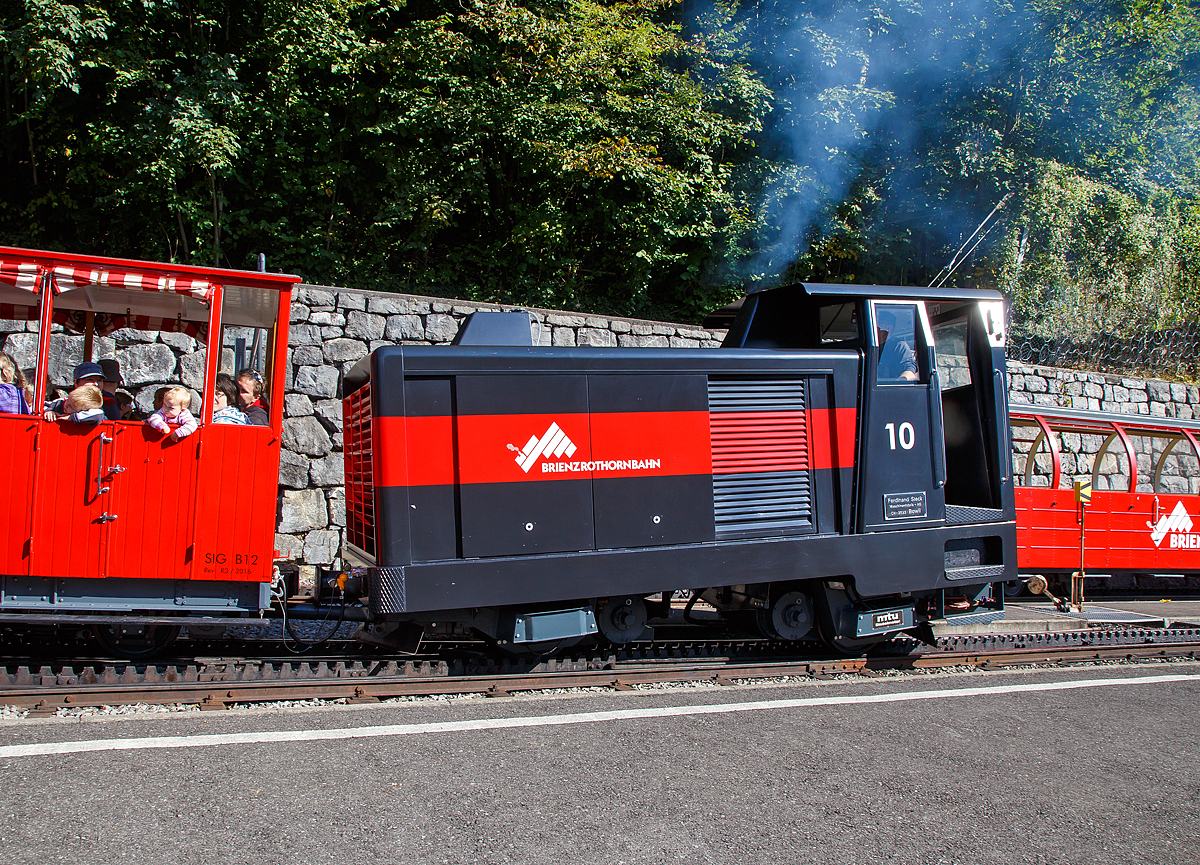 Auch eine Diesellok raucht....
Die Dieselhydraulische Hm 2/2 Zahnradlokomotive BRB 10 muss am 25.09.2016 als Verst�rkung fahren. Bei wundersch�nem Kaiserwetter, hatte es einen sehr gro�en Besucherandrang. Gleich drei vollbesetzte Z�ge fuhren um 10:50 Uhr hintereinander zum Brienzer Rothorn hinauf.

Brienz-Rothorn-Bahn (BRB) besitzt insgesamt drei solcher ganz spezieller Lokomotiven. Die Dieselhydrostatische Lok nach dem System Bernhard (Ingenieur Karl Bernhard) wurde 1975 von der Ferdinand Steck Maschinenfabrik AG in Bowil (CH) gebaut, der 600 PS starke Dieselmotor ist von der MTU. Im Jahr 2015 wurde die Lok von Steck in Bowil total revidiert.

Die werden vor allen im Bahndienst, z.B. f�r Materialtransporte f�rs Hotel oder f�r Umbauten, eingesetzt. Eine Lok wird immer als 'Entpannungs-' und Feuerwehrlok als Ersteinsatzelement in Brienz verf�gbar gehalten. Bei wirklich gro�em Andrang (wie an diesem Tage) oder bei technischen Ausf�llen, kann auch eine dieser Loks zum Personentransport eingesetzt werden.

TECHNISCHE DATEN:
Spurweite: 800 mm
Zahnstangensystem:  Abt
Achsfolge: 2zz (d.h. 2 nicht angetriebene Tragachsen, 2 Triebzahnr�der)
Triebzahnraddurchmesser: 573 mm 
Tragraddurchmesser: 653 mm 
Motorleistung: 485 kW / 660 PS

Kraft�bertragung:
Antriebsleistung durch Dieselmotor, �ber Verteilergetriebe werden zwei Axialkolbenpumpen (Hydraulikpumpen) angetrieben. Das �lf�rdervolumen und -Richtung werden durch zwei Proportionalventile gesteuert und speisen zwei parallel geschalteten Konstanthydraulikmotoren, die die Kraft �ber ein �bersetzungsgetriebe auf die Zahnr�der bringen. Somit ist dies ein ganz anders Antriebs Prinzip als bei einer Adh�sions-Diesellokomotive.
Bremsenergie hydraulisch �ber Bremsventil gedrosselt, nebst hydrostatischer Betriebsbremse noch zwei weitere, voneinander unabh�ngige Bremssysteme

Tankinhalt: 450 Liter (Diesel�l)
Verbrauch: 66 Liter Diesel�l-Bedarf pro Fahrt Brienz-Rothorn und retour
Zugkraft: 80 kN 
H�chstgeschwindigkeit: 14,0 km/h bei Bergfahrt, 250 ‰ und unter Volllast
H�chstgeschwindigkeit: 12,0 km/h H�chstgeschwindigkeit bei Talfahrt, 250 ‰ und unter Volllast

L�nge �ber Puffer: 5.250 mm 
Breite: 2.100 mm 
H�he: 3.200 mm H
Dienstgewicht: 13.200 kg 
    
Beschaffungskosten (1975):    450.000
Beschaffungskosten (1987-Lok 11): 1.000.00000 CHF 
