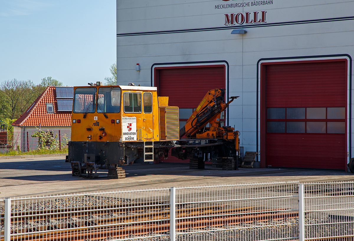 Aufgebockt ohne Achsen steht das Mehrzweckarbeitsfahrzeug Rolba Railway RR 2/200 (Baureihe MBW-A-02) der Florianer Bahn Forschungs- und Errichtungsgesellschaft m.b.H. am 15.05.2022 vor dem Lokschuppen der Mecklenburgische Bäderbahn Molli GmbH „Molli“ in Bad Doberan. Ob er an den Molli verkauft wurde, ist mir unbekannt.

Das Fahrzeug:
RR 2/200 ein Universell mit verschiedenen Anbaugeräten für den Sommer- und Wintereinsatz konzipiertes Fahrzeug, vom Hersteller Rolba AG, dieser war ein bekannter Hersteller von Kommunalfahrzeugen in Wetzikon. Gebaut wurden sowohl Regel- wie Schmalspurfahrzeuge. Die RR 2/200 ist mit einer Hebe- und Drehvorrichtung ausgerüstet, die es ermöglicht die komplette Einheit um 180° zu drehen. Zur Verfügung standen folgende Anbaugeräte:
•	ROLBA Schnee-Frässchleuderaggregat
•	Universal-Schneepflug und Heckpflug
•	Weichen-Kehrbürste
•	Ladekran
•	Ladepritsche 10 m², beidseitig kippbar
•	Hebebühne
•	Böschungsmäher
•	Baggerlader

Der Ursprung dieses Fahrzeuges ist die Florianerbahn, auch Straßenbahn Ebelsberg–St. Florian, auch genannt, ist eine eingestellte Straßenbahnstrecke in Oberösterreich. Sie war ursprünglich eine als Eisenbahn konzessionierte schmalspurige Lokalbahn zwischen der früher selbstständigen Gemeinde Ebelsberg (heute ein Stadtteil von Linz) und St. Florian. Im Jahr 2003 musste der Museumsbetrieb aufgrund nicht mehr ausreichender Standards bei Gleisanlagen und Fahrleitung eingestellt werden.

Die Spurweite beträgt wie jene der Linzer Straßenbahn 900 mm (bzw. wie hier der Molli), die Strecke ist mit 600 Volt Gleichstrom elektrifiziert. Der reguläre Betrieb dauerte vom 2. September 1913 bis zum Jahresende 1973. Ab 1929 war sie in Ebelsberg direkt mit dem Linzer Straßenbahnnetz verbunden, sodass Beiwagen von Linz bis St. Florian durchlaufen konnten.
