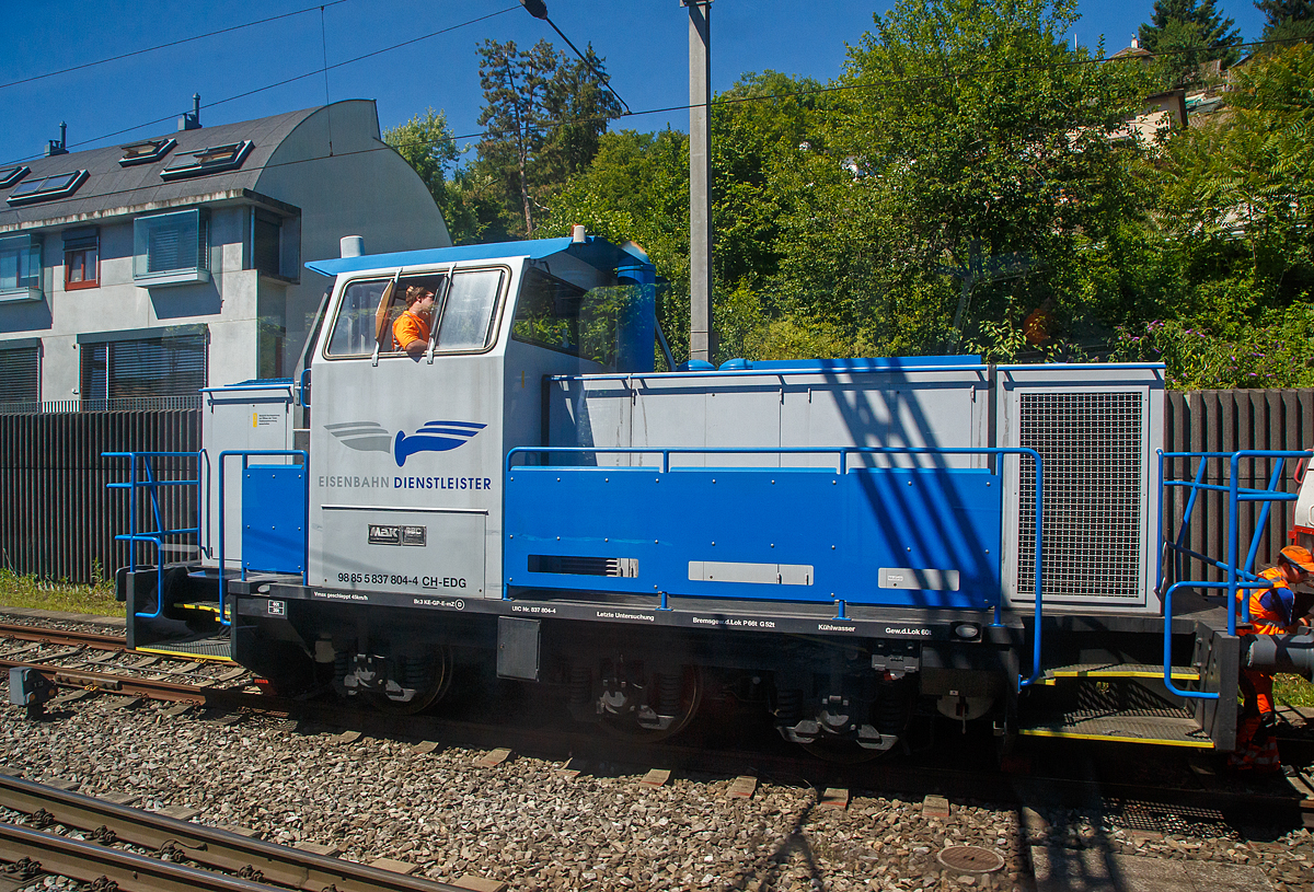 Aus dem Zug heraus konnte ich am 11.07.2022 bei Liestal die Em 837 804-4 (98 85 5837 804-4 CH-EDG, eine dreiachsige dieselelektrische MaK DE 502 der EDG - Eisenbahndienstleister GmbH, bei Rangierarbeiten erwischen. 

Die dreiachsige dieselelektrische MaK DE 502 wurde 1986  von der Krupp MaK Maschinenbau GmbH in Kiel gebaut, die elektrische Ausr�stung ist von BBC (Brown, Boverie & Cie. AG). Im Mai 1987 ging die Lok in die Schweiz an die Moos Stahl AG in Emmenbr�cke (ab 1993 Panlog AG). Im Februar 2017 ging sie an die EDG - Eisenbahndienstleister GmbH in Thayngen. 

Nach den Fortschritten in der Entwicklung der Drehstrom-Antriebstechnik wurde 1980 erstmals eine dreiachsige Lok mit elektrischer Leistungs�bertragung im dritten Typenprogramm angeboten. Ausger�stet mit MTU-Motoren des Typs 6V 331 TC12 bildet sie das Pendant zur G 761 C.

Als dann ab 1981 die neuen Motoren der Reihe 396 zur Verf�gung standen wurde bei den dieselelektrischen Loks die Typenbezeichnung in DE 502 ge�ndert. Zus�tzlich wurde die elektrische Ausr�stung auf den aktuellen Stand der Technik gebracht.

Von der Standardausf�hrung wichen einige Loks beider Typen ab, die mit MWM-Motoren ausger�stet wurden. Geliefert wurden sie an die Ruhrkohle AG und an BASF.

TECHNISCHE DATEN der DE 502:
Anzahl:  13 (7 mit MTU und 6 mit MWM Motoren)
Spurweite:  1.435 mm (Normalspur)
Achsformel:  Co
L�nge �ber Puffer:  9.870 mm
H�he:  4.220 mm
Breite:  3.100 mm
Gesamtradstand:  3.800 mm
Treibraddurchmesser:  1.000 mm
Kleinster bef. Halbmesser:  40 m
Dienstgewicht:  60 t
H�chstgeschwindigkeit:  45 km/h (einen und geschleppt)
Installierte Leistung:  560 kW (bei 1.800 U/min)
Anfahrzugkraft: 255 kN
Motorentyp:  MTU 6V336TC13 (V 6 Zylinder Dieselmotor)  
Leistungs�bertragung:  elektrisch  (Hersteller  BBC)
Tankinhalt:  1.700 l