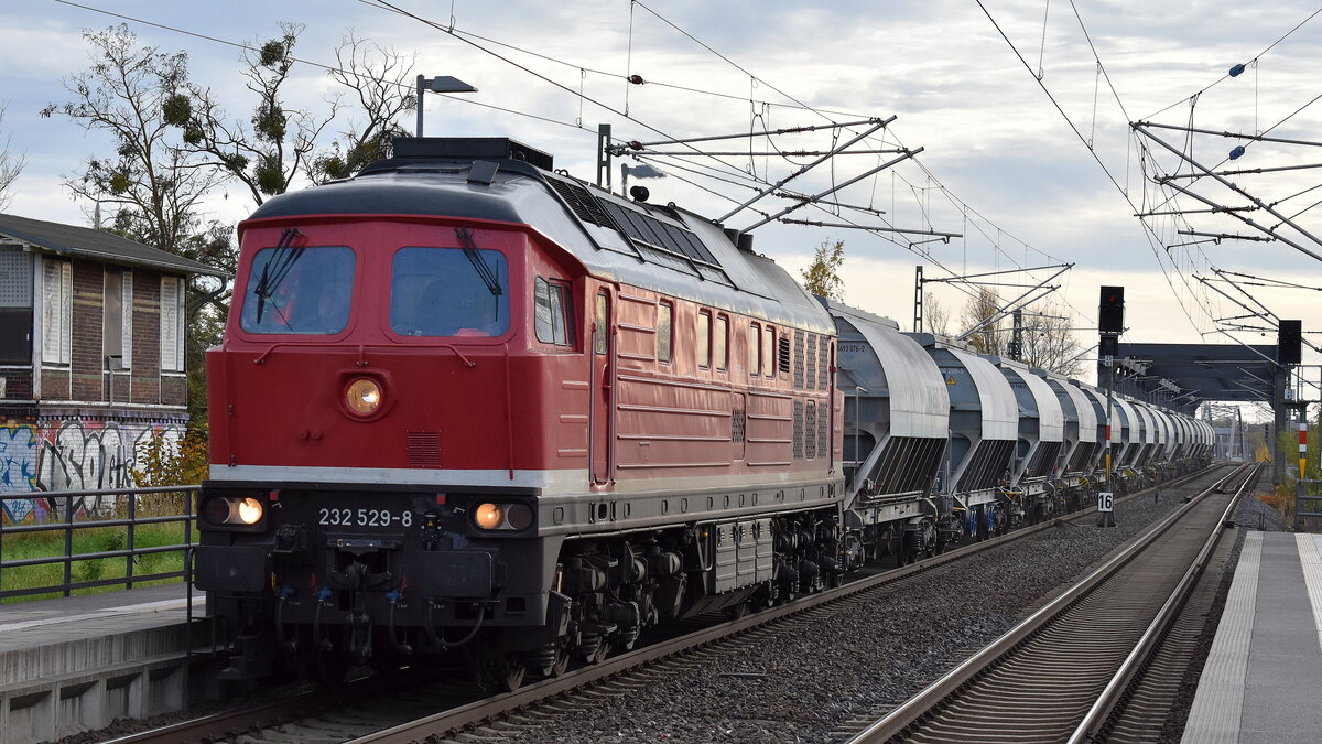 Bahnbetrieb Gera GmbH mit der von der Traktion4Rent GmbH angemieteten Ludmilla  232 529-8  (NVR:  92 80 1232 529-8 D-GERA ) und einigen Staubgutwagen am 04.11.25 Durchfahrt Bahnhof Roßlau (Elbe).