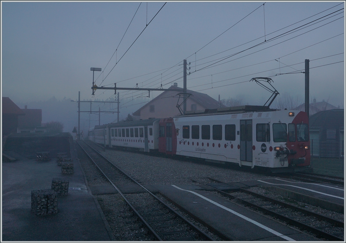 Bei dichtem Nebel und noch in der Morgendämmerung erreicht der TPF Be 4/4 121 mit dem B 207, B209 und dem ABt 221 den Bahnhof von Broc Village. Der Zug ist als RER 60 14954 von Bulle nach Broc Farbrique unterwegs. . Ab nächstem Jahr soll die Strecke von Bulle nach Broc Farbrique auf Normalspur umgebaut werden.


26. Nov. 2020