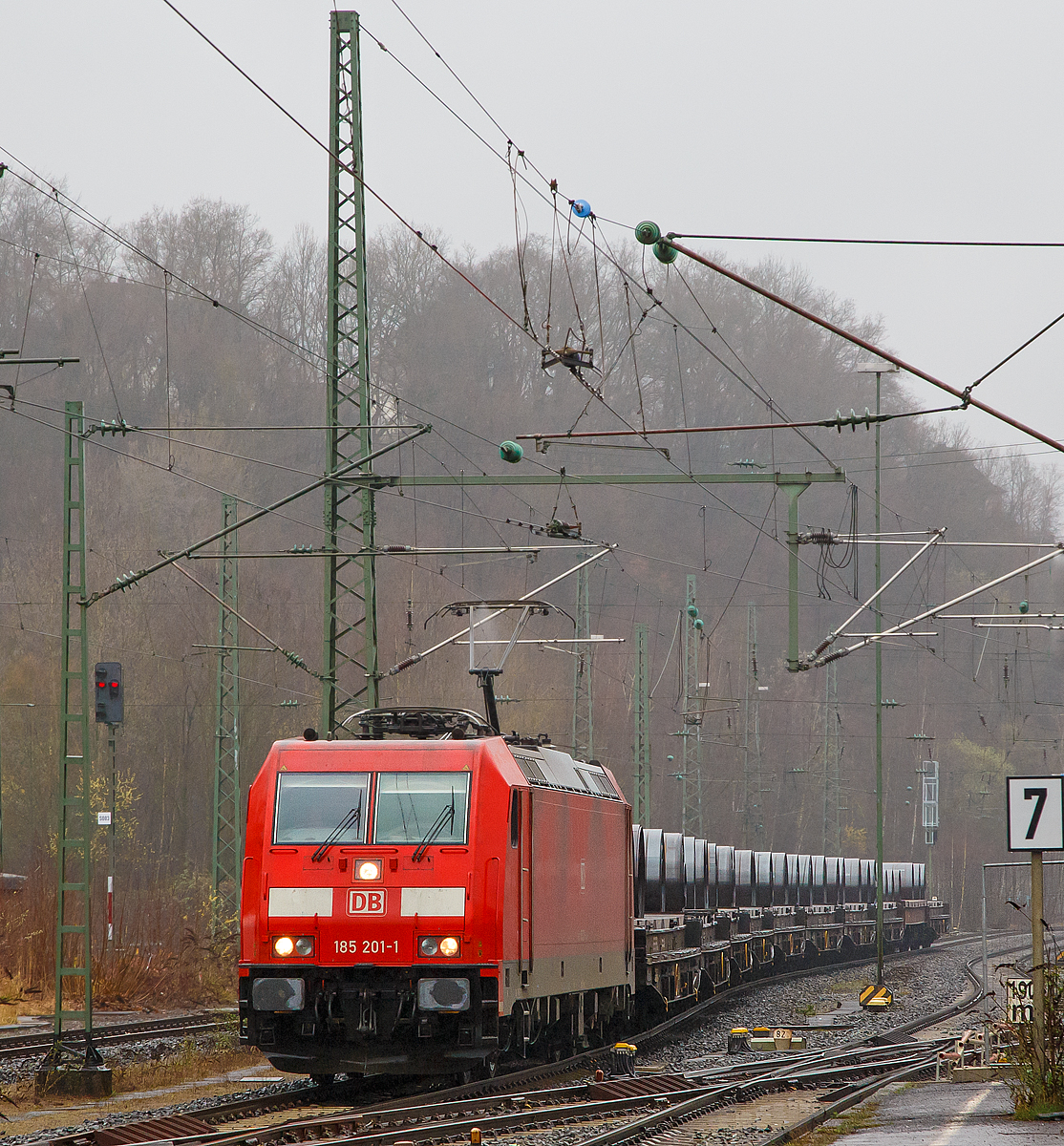 
Bei strömenden Regen fährt die 185 201-1 (91 80 6185 201-1 D-DB) der DB Cargo Deutschland AG mit einem Coilzug (mit Warmband-Coils beladene Drehgestell-Flachwagen mit Lademulden für Coils  der Gattung Sahmms-t 710 ) am 18.03.2017 durch Betzdorf/Sieg in Richtung Siegen.