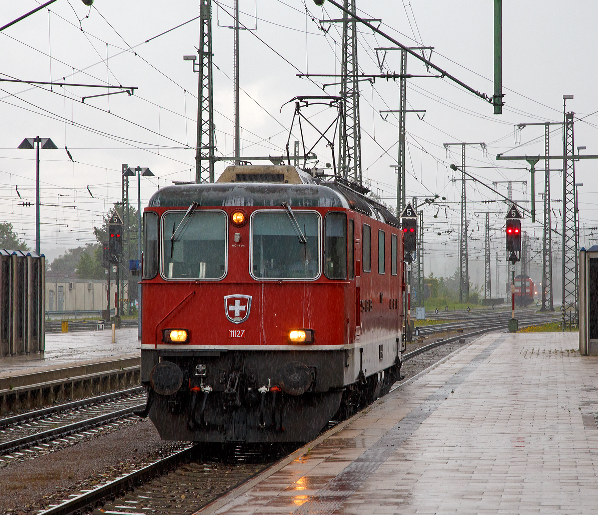 
Bei strömenden Regen setzt sich nun die SBB Re 4/4 II - 11127 bwz. Re 420 127-3 (91 85 4 420 127-3 CH-SBB) am 17.06.2016 im Bahnhof Singen (Hohentwiel) vor den IC 185 (Suttgard Hbf - Singen - Zürich HB).