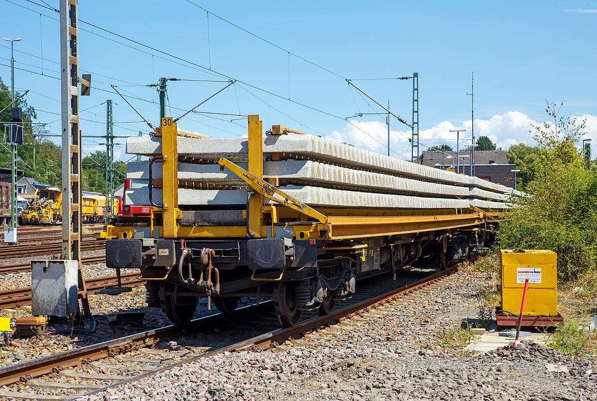 
Beladener Schwellenwagen der Schweerbau abgestellt am 15.07.2018 im Bahnhof Au (Sieg). Der Schwellenwagen besteht aus einem Drehgestell-Containertragwagen der Gattung Sgs (37 80 4541 030-5 D-WSG) und einem 8,7 t schweren Traggestell (Schwellenträger-Modul). Zwischen den einzelnen Wagen können im Baubetrieb Überfahrbrücken, für die Schwellen-Portalkrane vom Umbauzug, eingelegt werden. So können dann die Portalkrane über den ganzen Schwellenzug fahren, um Schellen zu entnehmen bzw. Alt-Schwellen wieder anzulegen, siehe http://hellertal.startbilder.de/bild/Deutschland~Unternehmen~Schweerbau/184517/schweizer-hightech-auf-der-kbs-445.html

Der Wagen ist eingestellt durch Waggonservice WSG mbH.

Technische Daten:
Spurweite: 1.435 mm
Länge über Puffer: 19.640 mm
Länge der Ladefläche: 18.400 mm
Drehzapfenabstand: 14.600 mm
Radsatzstand in den Drehgestellen: 1.800 mm
Raddurchmesser: 920 mm (neu) / 860 mm (abgenutzt)
Eigengewicht (Wagen): 18.500 kg
Gewicht des Ladegestells: 8.670 kg
Maximales Ladegewicht: 62,3 t (ab Streckenklasse C)
Max. Geschwindigkeit: 100 km/h (leer 120 km/h)
kleinster befahrbarer Gleisbogenradius: R 75 m (bei eingelegten Überfahrbrücken R 190 m)
Bremse: Ch-GP-A
Handbremse: Ja
