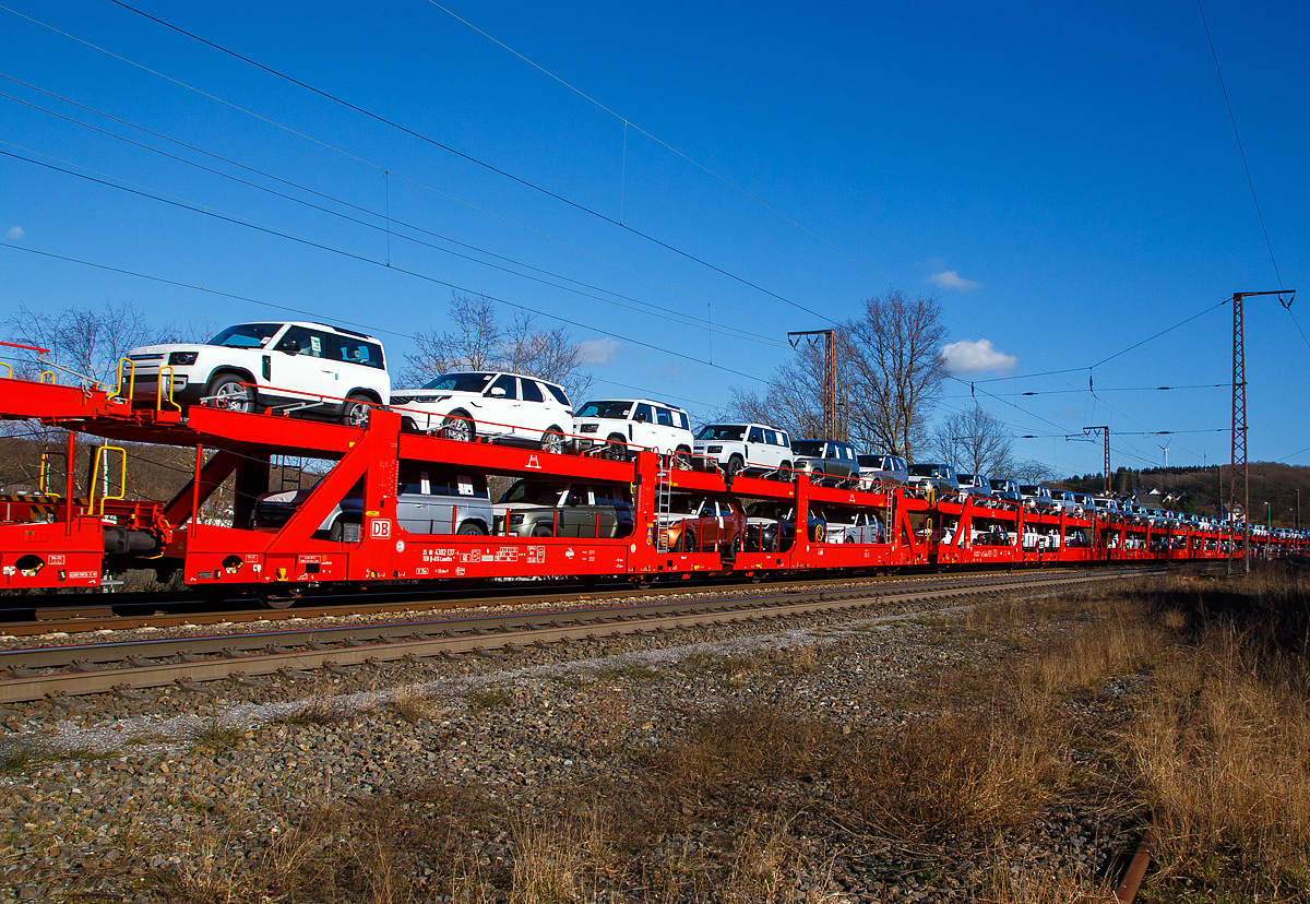 Beladener vierachsiger Doppelstock-Autotransportwagen 25 80 4382 137-4 D-ATG der Gattung Laaeffrs 561 der DB Cargo Logistics GmbH (ex ATG Autotransportlogistic GmbH) am 27.02.2021 im Zugverband bei der Durchfahrt in Rudersdorf (Kr. Siegen) an der Dillstrecke (KBS 445) in Richtung Siegen.

Die Wagen der Gattung Laaeffrs 561 sind im Rahmen von dem Projekt „Innovativer Güterwagen“ neuentwickelte Wagen. Es ist auch die Antwort auf den sich verändernden Automobilmarkt, auf dem zunehmend größere und schwerere Fahrzeuge gefragt sind (SUV). So eignen sich diese Wagen insbesondere für den europaweiten Transport von großvolumigen Pkws, SUVs und Vans, auch bei kleineren Lichtraumprofilen. Mit der hohen Lastgrenze von 35,5 Tonnen ist der Transport von besonders schweren Fahrzeugen möglich.

Damit sowohl ein typenreiner Transport als auch eine Mischverladung in den unterschiedlichen Lademaßen möglich ist, kann die obere Ladeebene hinsichtlich der Transportstellungen stufenlos eingestellt werden. Flexible Elemente der unteren Ladeebene sowie eine spezielle Geometrie der oberen Ladeebene dienen zusätzlich der effizienteren Ausnutzung des Laderaums bei besonders hohen Pkw.

Zur Ladungssicherung befinden sich auf der oberen und unteren Ladeebene jeweils 32 Radvorleger. Eine Besonderheit ist auch die erhöhte Arbeitssicherheit durch das Klappgeländer auf der oberen Ladeebene.

Die Vorteile auf einen Blick:
– Zweigliedriger, doppelstöckiger Autotransportwagen
– Hohe Lastgrenze
– Große Durchfahrhöhe
– Obere Ladeebene flexibel einstellbar
– Untere Ladeebene mit verstellbaren Elementen für eine höhere Auslastung
– Verringerte Gesamthöhe durch besondere Geometrie der oberen Ladeebene
– Klappbare Absturzsicherung auf der oberen Ladeebene

TECHNISCHE DATEN:
Gattung: Laaeffrs 561
Baujahr: ab 2019
Hersteller (u.a.): Tatravagónka a.s. Poprad (Slowakei)
Spurweite: 1.435 mm
Anzahl der Achsen: 4
Länge über Puffer : 33.000 mm
Ladelänge : 32.080 mm (unten) / 32.550 mm (oben)
Ladebreite : 2.950 mm (unten) / 2.794 mm (oben)
Wagenhöhe: 3.500 mm
Abstand der äußeren Radsätze: 27.300 mm (10.700 / 5.900 / 10.700 mm)
Laufraddurchmesser (neu): äußere 760 mm und mittlere 730 mm
Höchstgeschwindigkeit: 100 km/h (120 km/h leer)
Eigengewicht: 36.510 kg
Nutzlast: 35,5 t ab Streckenklasse B (max. 18 t pro Ebene)
Max. Gewicht je Pkw: 2.800 kg
Kleinster befahrb. Gleisbogenhalbmesser: R 75 m
Höhe des Klappgeländers: 1.100 mm 
Bermse: KNORR KE-GP-A, 2x10“
Intern. Verwendungsfähigkeit: TEN - GE 
