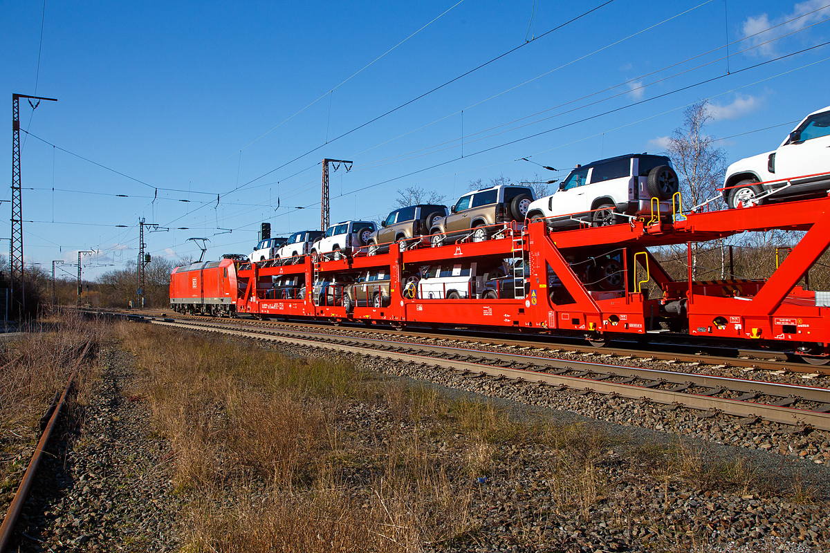 Beladener vierachsiger Doppelstock-Autotransportwagen 25 80 4382 030-1 D-ATG der Gattung Laaeffrs 561 der DB Cargo Logistics GmbH (ex ATG Autotransportlogistic GmbH) am 27.02.2021 im Zugverband bei der Durchfahrt in Rudersdorf (Kr. Siegen) an der Dillstrecke (KBS 445) in Richtung Siegen.

Die Wagen der Gattung Laaeffrs 561 sind im Rahmen von dem Projekt „Innovativer Güterwagen“ neuentwickelte Wagen. Es ist auch die Antwort auf den sich verändernden Automobilmarkt, auf dem zunehmend größere und schwerere Fahrzeuge gefragt sind (SUV). So eignen sich diese Wagen insbesondere für den europaweiten Transport von großvolumigen Pkws, SUVs und Vans, auch bei kleineren Lichtraumprofilen. Mit der hohen Lastgrenze von 35,5 Tonnen ist der Transport von besonders schweren Fahrzeugen möglich.

Damit sowohl ein typenreiner Transport als auch eine Mischverladung in den unterschiedlichen Lademaßen möglich ist, kann die obere Ladeebene hinsichtlich der Transportstellungen stufenlos eingestellt werden. Flexible Elemente der unteren Ladeebene sowie eine spezielle Geometrie der oberen Ladeebene dienen zusätzlich der effizienteren Ausnutzung des Laderaums bei besonders hohen Pkw.

Zur Ladungssicherung befinden sich auf der oberen und unteren Ladeebene jeweils 32 Radvorleger. Eine Besonderheit ist auch die erhöhte Arbeitssicherheit durch das Klappgeländer auf der oberen Ladeebene.

Die Vorteile auf einen Blick:
– Zweigliedriger, doppelstöckiger Autotransportwagen
– Hohe Lastgrenze
– Große Durchfahrhöhe
– Obere Ladeebene flexibel einstellbar
– Untere Ladeebene mit verstellbaren Elementen für eine höhere Auslastung
– Verringerte Gesamthöhe durch besondere Geometrie der oberen Ladeebene
– Klappbare Absturzsicherung auf der oberen Ladeebene

TECHNISCHE DATEN:
Gattung: Laaeffrs 561
Baujahr: ab 2019
Hersteller (u.a.): Tatravagónka a.s. Poprad (Slowakei)
Spurweite: 1.435 mm
Anzahl der Achsen: 4
Länge über Puffer : 33.000 mm
Ladelänge : 32.080 mm (unten) / 32.550 mm (oben)
Ladebreite : 2.950 mm (unten) / 2.794 mm (oben)
Wagenhöhe: 3.500 mm
Abstand der äußeren Radsätze: 27.300 mm (10.700 / 5.900 / 10.700 mm)
Laufraddurchmesser (neu): äußere 760 mm und mittlere 730 mm
Höchstgeschwindigkeit: 100 km/h (120 km/h leer)
Eigengewicht: 36.510 kg
Nutzlast: 35,5 t ab Streckenklasse B (max. 18 t pro Ebene)
Max. Gewicht je Pkw: 2.800 kg
Kleinster befahrb. Gleisbogenhalbmesser: R 75 m
Höhe des Klappgeländers: 1.100 mm 
Bermse: KNORR KE-GP-A, 2x10“
Intern. Verwendungsfähigkeit: TEN - GE 
