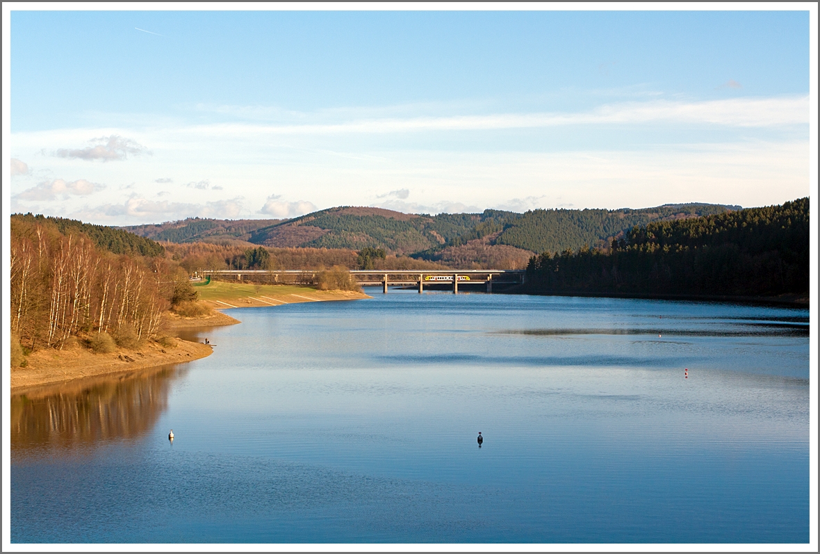 Blick am 02.02.2014 von der Staumauer der Listertalspeere auf den Biggesee und die Doppelstockbrücke Listertal, worüber gerade der Dieseltriebwagen VT 270 ein Alstom Coradia LINT 41 der HLB (Hessischen Landesbahn) als RB 92  Biggesee-Express  in Richtung Olpe fährt.

Es ist ungewöhnlich, dass die HLB bereits auf dieser Strecke anzutreffen ist, denn eigentlich fährt dieses Jahr noch die 3-Länder-Bahn (DB Regio). Grund war wohl eine GPSinfradat-Fahrt, evtl. für spätere Interaktive Schulung der Fahrzeugführer der HLB auf der Strecke, da die HLB ab 2015 das gesamte Dieselnetz in der Region (Dieselnetz Eifel-Westerwald-Sieg) bedient.

Der LINT 41 wurde 2011 von Alstom gebaut, er hat die NVR-Nummern 95 80 0648 010-6 D-HEB und 95 80 0648 510-5 D-HEB und die EBA-Nummer EBA 10C 08B 001.

Übrigens das ich hier die Triebwagennummer genau weiß, verdanke ich der Tatsache, dass ish den Triebwagen in Olpe auf unserer Heimreise noch antreffen konnte.
 