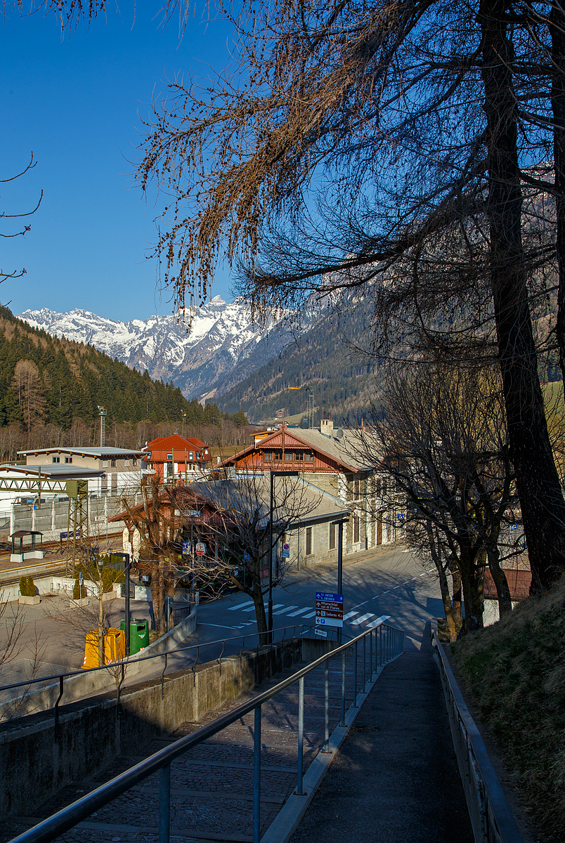 Blick auf den Bahnhof Gossensaß/Colle Isarco am 27.03.2022.
Der Bahnhof Gossensaß (auch Gossensass; italienisch Stazione di Colle Isarco) befindet sich an der Brennerbahn in Südtirol (italienisch Alto Adige), amtlich Autonome Provinz Bozen – Südtirol.

Der Bahnhof Gossensaß ist der erste Haltepunkt im Wipptal südlich des Brennerpasses, zu dem die Bahnstrecke von hier aus über den Pflerschtunnel ansteigt. Er liegt auf 1.066,9 m Höhe nahe dem Zentrum von Gossensaß, dem Hauptort der Gemeinde Brenner, und der durch das Dorf führenden SS 12 (der alten Brennerpass-Straße). 

Der Bahnhof wurde 1867 zusammen mit dem gesamten Abschnitt der Brennerbahn zwischen Innsbruck und Bozen in Betrieb genommen. Durch ihn erlebte Gossensaß bis zum Ersten Weltkrieg seine Blütezeit als bekannter Touristenort. Er konkurrierte mit Orten wie St. Moritz oder Chamonix. 

Das Aufnahmegebäude war zunächst noch relativ kompakt gehalten, wurde wegen der vielen Touristen jedoch noch im 19. Jahrhundert durch einen südlichen Anbau erweitert. Das ursprüngliche Gebäude weist eine Verkleidung aus Grauwacke auf, während dekorative Details wie die Fensterfassungen in weißem Kalkstein gehalten sind. Straßenseitig ist es durch einen in sorgfältigen Details gearbeiteten Dachgiebel aus Holz gestaltet. Der Anbau ist in Brixner Granit gemauert und sticht durch eine hölzerne Veranda hervor. In dem sich heute das Buffet befindet und man auch den Espresso genießen kann. Das Gebäude steht seit dem Jahr 2000 unter Denkmalschutz.

Der Bahnhof Gossensaß wird durch Regionalzüge der Trenitalia sowie der SAD bedient, die auch Busverbindungen zum Bahnhof betreibt. Die Regionalzüge fahren in beide Richtung (Brenner bzw. Bozen) im Stundentakt und werden zu Hauptverkehrszeiten durch Regionalexpresszüge verdichtet.

Uns hat es in Gossensaß sehr gut gefallen, es war einfach zu kurz, so dass wir gerne wiedermal dort hinfahren wollen. Für die drei Tage haben wir uns ein Südtirol/Alto Adige Ticket (eine Mobilcard für 3 Tage) am Automat für 23,00 Euro geholt. So konnten wir mit diesem Ticket Südtirol mit der Bahn erkunden. 
