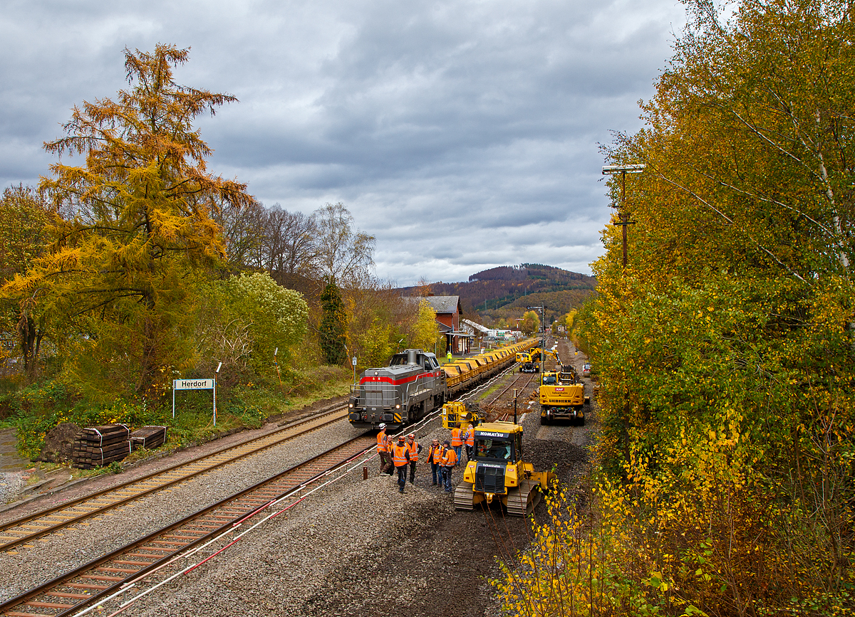 
Blick auf den Bahnhof Herdorf am 02.11.2020. Am Sonntag den 01.11.2020 war auf der Baustelle Ruhetag, heute wird wieder gearbeitet, der Oberbau von Gleis 4 wurde heute Morgen demontiert, nun hat der Aushub vom Schotterbett begonnen. Auf Gleis 2 steht die Vossloh G 12 „Karl August“ 92 80 4120 001-7 D-KAF der KAF Falkenhahn Bau AG mit einem Kippwagenzug (Kippwagen MK 45 DH „LW-Kipper“, der Gattung Rlps), der mit dem Aushub (Altschotter) beladen wird. Der Altschotter  wird später zum Recycling nach Bochum abgefahren.

Übrigens, die Lok trägt den Namen des Firmengründers Karl August Falkenhahn, der die Baufirma 1919 in Kreuztal gründete.

