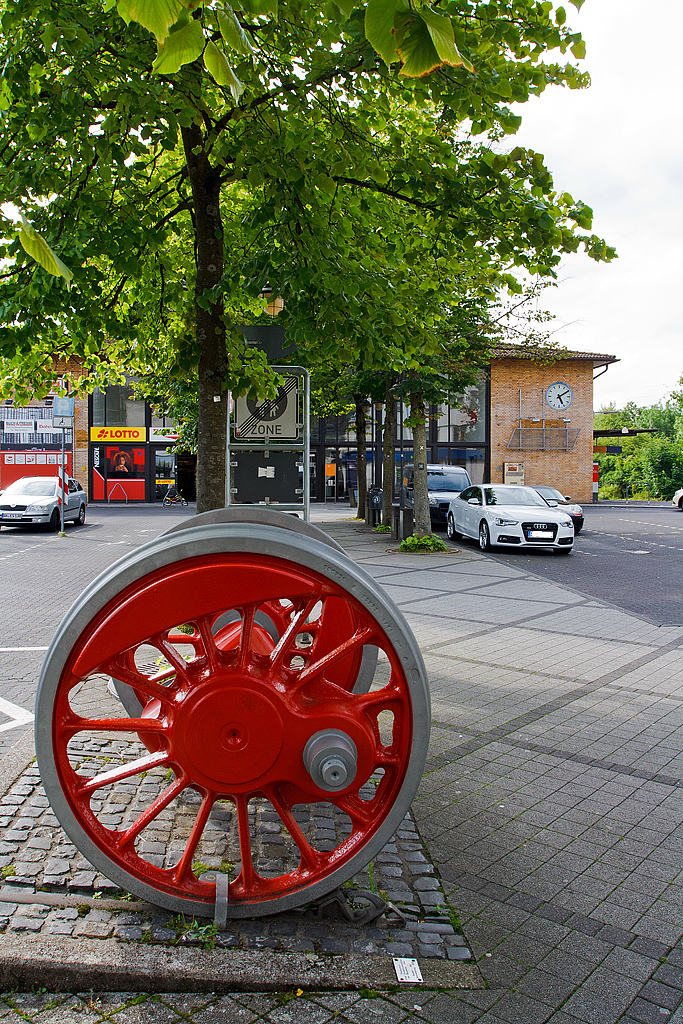 Blick auf das Empfangsgeb�ude vom Bahnhof Betzdorf/Sieg (am 13.07.2014). Im Vordergrund eine Treibachse einer Dampflokomotive der Baureihe 044 (Baujahr 1942, Ausmusterung 1973). Bis in die 1970er-Jahre waren im AW Betzdorf auch  Jumbo´s  (Dampflok der BR 044) beheimatetet.
