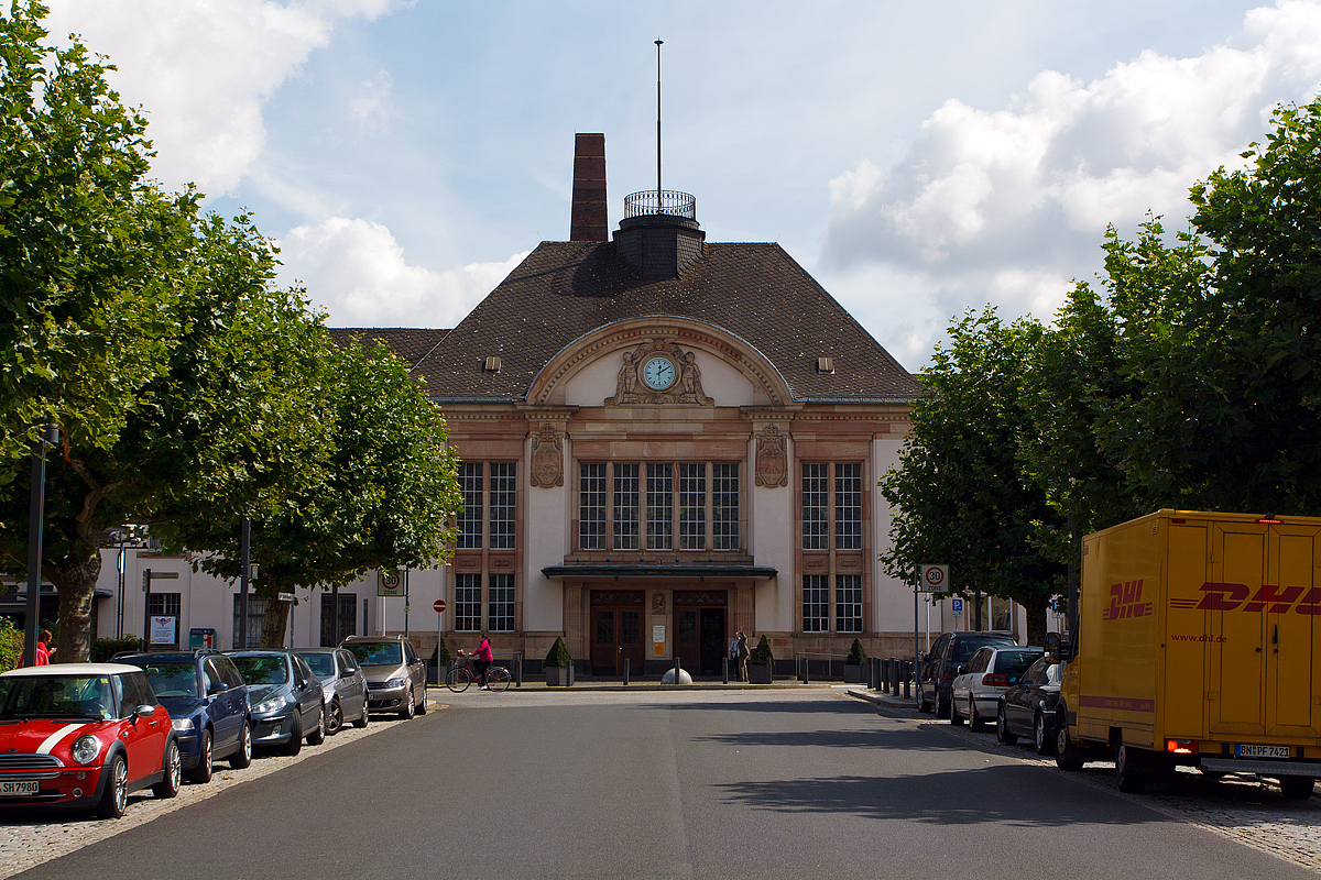 
Blick auf den Haupteingang vom Empfangsgebäude des Bahnhofs Bad Nauheim am 20.08.2014. Der Bahnhof liegt an Streckenkilometer 161,9 der Main-Weser-Bahn (KBS 630).

Das heutige Empfangsgebäude wurde 1911–1913 in neoklassizistischen Formen errichtet. Die Fassade trägt sowohl das preußische als auch das hessische Wappen, da Bad Nauheim zum Großherzogtum Hessen gehörte, Bahnhof und Main-Weser-Bahn aber von der Preußischen Staatseisenbahn betrieben wurden.