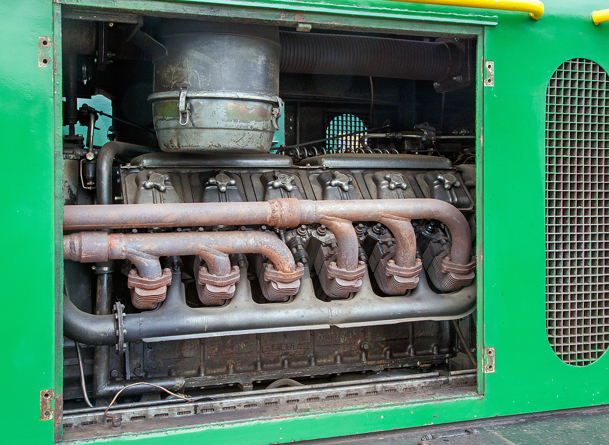 Blick auf den Motor der D2 der Brohltalbahn, hier am 24.05.2015 in Oberzissen....
Der luftgekühlte 90 Grad V12-Zylinder- Viertakt-Dieselmotor mit Abgasturbolader vom Typ Deutz BF 12L714
Er hat eine Dauerleistung von 300 PS (221 kW) und einen Hubraum von 19 l (Bohrung Ø 120 mm x Hub 140 mm).