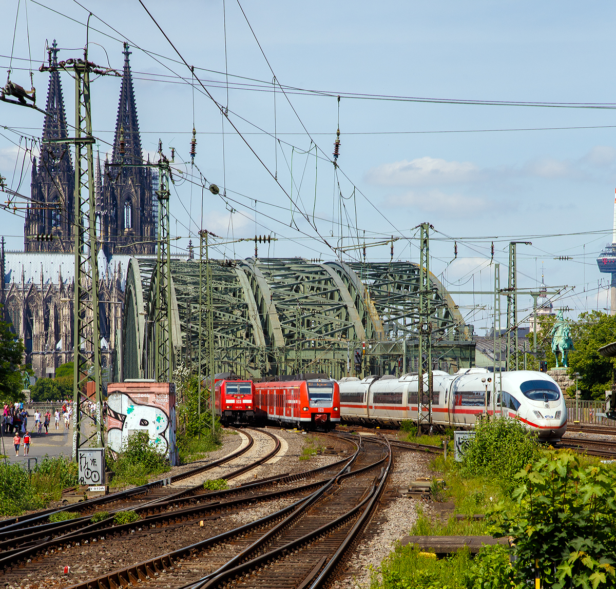 
Blick vom Bahnhof Köln Messe/Deutz am 01.06.2019 auf die Hohenzollernbrücke, dahinter folgt sofort der Hauptbahnhof Köln mit der weltweit größten Bahnhofskapelle, dem Kölner Dom.

Von der Hohenzollernbrücke kommen gerade (von links nach rechts) die DB 146 274-6 mit dem RE 5 “Rhein-Express“  und der ET 425 098-1 als RE 8 “Rhein-Erft-Express“, sowie NS (Nederlandse Spoorwegen) ICE 3M Tz 4653  erreicht bald den  Hbf.