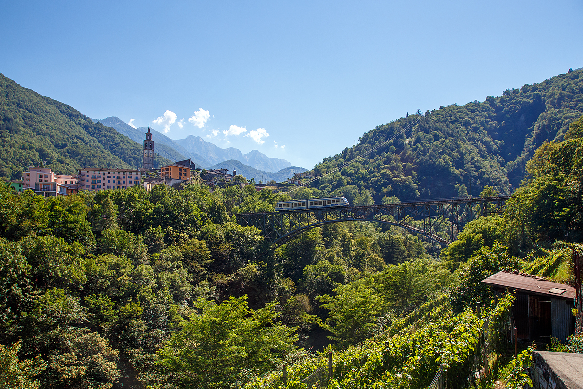 
Centovallibahn - Der FART Gelenk-Triebwagen ABe 4/6 54 hat am 22.06.2016 Intragna (Tessin) verlassen und fährt nun über die 132 Meter lange Isorno Brücke in Richtung Lucano. Mit 65 Metern ist der San Gottardo, in Intragna, der höchste Kirchturm im Kanton Tessin. Leider ließ der Sonnenstand keinen anderen Blickwinkel zu.