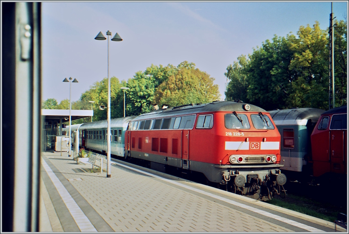 Damals noch überall anzutreffen: die DB 218; hier aus dem Fenster des  Kleber Express bei Halt in Memmingen fotografiert: die DB 218 22-5 in frischem  Neurot .

Analogbild vom 11. Oktober 2001