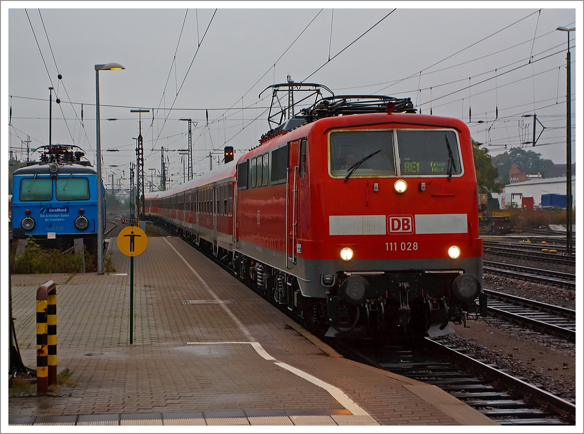 Das Ergebnis von dem Regenfotograf....
Die 111 028 mit dem RE 1   Mosel-Saar-Express    Koblenz  – Wittlich  – Trier f�hrt am 05.10.2013 in den Hbf Trier ein, f�r diesen Umlauf ist es die Endstation, ansonsten f�hrt der RE 1 via Saarlouis und V�lklingen  bis Saarbr�cken