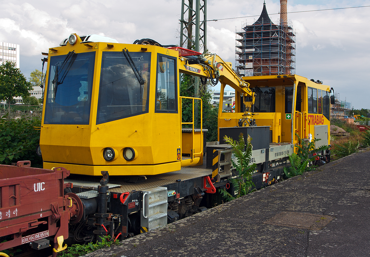 
Das Gleisarbeitsfahrzeug  99 80 9150 001-2 D-STRA der STRABAG Rail, ein Robel Bamowag 54.20, ist am 11.08.2014 beim Hauptbahnhof Wiesbaden angestellt. 

Der Bamowag 54.20 wurde 2010 von der ROBEL Bahnbaumaschinen GmbH in Freilassing unter der Fabriknummer 57.20-0003 gebaut. Das GAF hat in beiden Kabinen einen F�hrerstand, wobei Kabine mit dem TEREX Greifer sich auf einem Drehkranz befindet. 

Technische Daten (laut Anschriften): 
Spurweite: 1.435 mm 
L�nge �ber Puffer: 14.400 mm 
Achsabstand: 9.000 mm 
Kleinster bef. Gleisradius: R 95 m 
Zul. Streckenklasse: C2/CM2 und h�her 
Eigengewicht: 37.000 kg 
Nutzlast: 5 t Zul. 
Anh�ngelast: 100 t 
H�chstgeschwindigkeit: 100 km/h 
Zur Mitfahrt zugel. Personen: 5