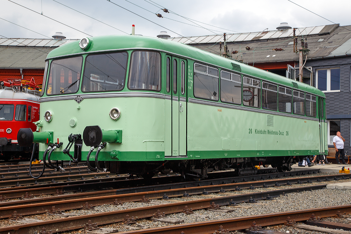 
Das Highlight des diesjährigen Lokschuppenfestes am 08. und 09.08.2015 im Südwestfälisches Eisenbahnmuseum in Siegen (hier 08.08.2015) war der Uerdinger-Schienenbus in der Farbgebung der Kleinbahn Weidenau-Deuz als KWD VT 26.

Es ist aber nicht das Original, denn dies wäre ein VT 95 – BR 795 (und nicht ein VT 98 – BR 796 / BR 798). Diese Fahrzeuge verfügten nur über einen Büssing-Unterflur-Motor und ein Sechs-Gang-Getriebe. Aber sie hatten einen verstärkten Rahmen, der dem späteren zweimotorigen VT 98. Normalerweise besaßen die VT 95 Mittelpufferkupplungen und Stoßfederbügel.

Das Original wurde 1956 von der Waggonfabrik Uerdingen unter der Fabriknummer 62482 gebaut und bei der Kleinbahn Weidenau - Deuz in Betrieb als VT 26 genommen. Dort fuhr er bis zur Stilllegung des Personenverkehrs der Kleinbahn Weidenau - Deuz 1968 und wurde an die AKN - Altona - Kaltenkirchen - Neumünster Eisenbahn AG verkauft, wo er noch in KWD-Lackierung als VT 2.23 bis zur Verschrottung 1978 fuhr.

Die Kleinbahn Weidenau–Deuz GmbH war eine Bahngesellschaft, die Eigentümerin der normalspurigen Bahnstrecke von Siegen-Weidenau nach Irmgarteichen-Werthenbach war. Der Personen- und Güterverkehr auf dem 11,3 Kilometer langen Teilstück von Weidenau nach Deuz wurde am 1. Dezember 1906 aufgenommen. Die Fortsetzung bis Irmgarteichen-Werthenbach (4,8 km) folgte für Personenzüge am 1. Dezember 1916 und für Güterzüge am 21. Mai 1917. 

Über mehrere Jahrzehnte entwickelten sich die Verkehrsleistungen positiv. Auch nach der Einstellung des Personenverkehrs am 25. Mai 1968 nahm der Güterverkehr noch zu.

Am 1. Januar 1970 wurde die Kleinbahngesellschaft Weidenau–Deuz GmbH aufgelöst und ihr Vermögen auf die Siegener Kreisbahn (heute Kreisbahn Siegen-Wittgenstein) übertragen, die mehr als 90 Prozent der Gesellschaftsanteile in Besitz hatte und schon seit dem 1. April 1955 Betriebsführerin war. Erst in den Jahren ab 1990 begann der Rückgang.  Viele Teilstücke sind heute demontiert.

Der reguläre Betrieb beschränkt sich heute auf den Bereich Weidenau Vorbahnhof bis Dreis-Tiefenbach, dort werden mehrere Industriebetriebe noch bedient. Mittlerweile endet das Gleis bei KM 2,9 im Werk Bombardier (ehemals Waggon Union - WU). Dieses stellt Drehgestelle für Schienenfahrzeuge her, früher ganze Güterwaggons.

