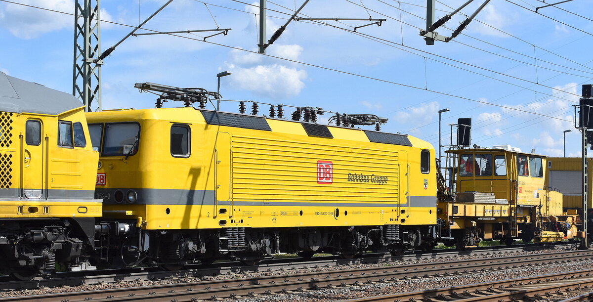 DB Bahnbau Gruppe GmbH, Berlin mit ihrer Ludmilla  232 550-4  (NVR:  92 80 1232 550-4 D-DBBBG ) mit  143 352-3  (NVR:  91 80 6143 352-3 D-DB ) und PLASSER & THEURER MAMMUT Schnellumbauzug SUZ 500 UVR  SUM 314  + Beiwagen/Gleisbaumaschinen am Haken am 21.04.26 Höhe Bahnhof Rodleben.