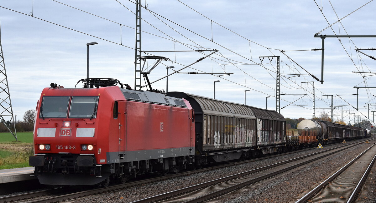 DB Cargo AG, Mainz [D] mit ihrer  185 163-3  [NVR-Nummer: 91 80 6185 163-3 D-DB] und einem gemischten Güterzug am 04.11.25 Höhe Bahnhof Rodleben.