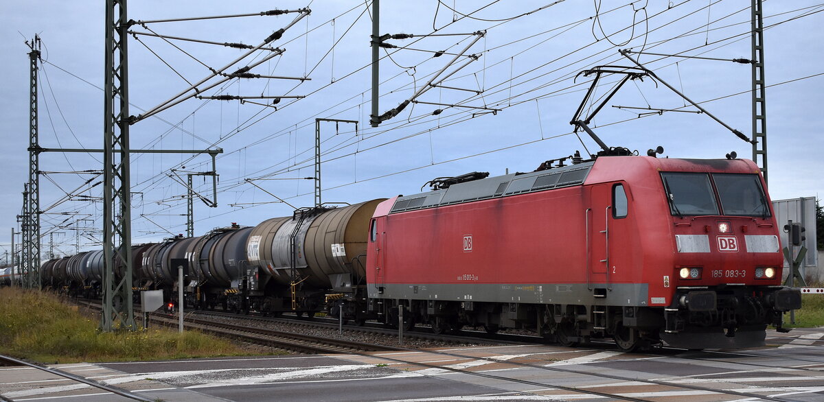 DB Cargo AG, Mainz [D] mit ihrer 185 083-3  [NVR-Nummer: 91 80 6185 083-3 D-DB] und einem Kesselwagenzug am 04.11.25 Höhe Bahnübergang Bahnhof Rodleben.