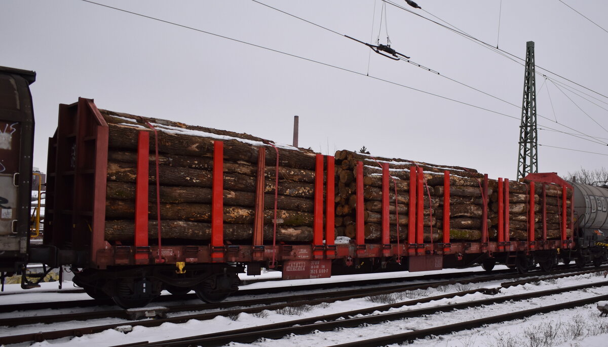 DB Cargo AG, Mainz [D] mit einem Drehgestell-Flachwagen mit vier Radsätzen, Stirnwänden und Rungen, jedoch ohne Seitenwände. Die Wagen sind speziell für den Transport von langen und schweren Ladegütern vorgesehen - vorrangig für Nadelstammholz, Eichen- und Buchenstammholz sowie Schnittholz. im Bild der Wagen mit der Nr. 37 RIV 80 D-DB SNI 3525 600-7 Roos-t 645 in einem gemischten Güterzug am 29.01.26 Höhe Bahnhof Magdeburg Neustadt.
