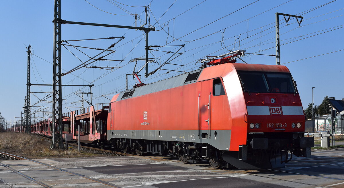 DB Cargo AG, Mainz [D] mit ihrer   152 153-3  [NVR-Nummer: 91 80 6152 153-3 D-DB] und einem PKW-Transportzug (leer) am 19.03.26 Höhe Bahnübergang Rodleben.