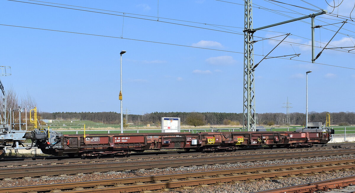 DB InfraGO AG, Frankfurt (Main) / DB Netz Instandhaltung mit einem Niederflurwaggon (zum Transport von Baufahrzeugen oder -maschinen) mit der Nr. 81 80 D-DBMP 4979 005-3 Sdmmrs am Haken von „203 309-0“ am 19.03.26 Höhe Bahnübergang Rodleben.