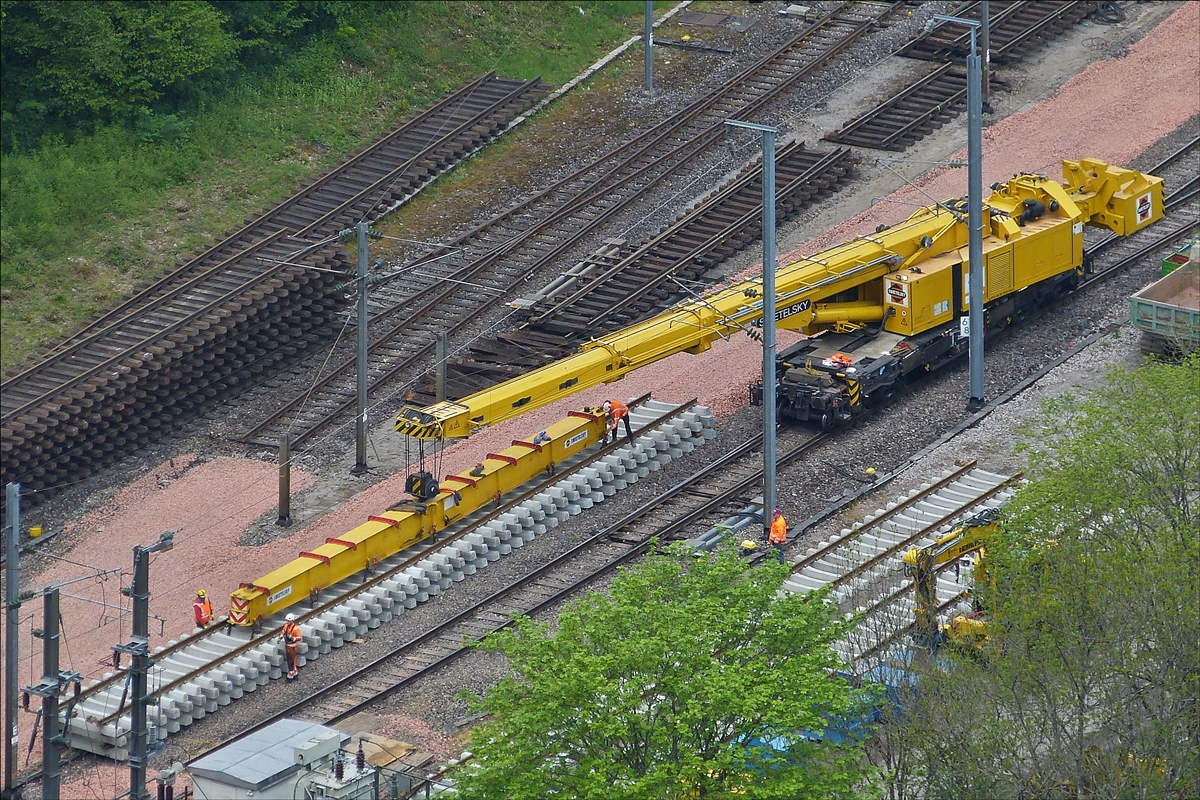 Der 150 t Kirow Gleis- und Weichenbaukran KRC 1200, 99 81 9119 004-, der Firma Swietelsky bei Gleisbauarbeiten im Bahnhof Kautenbach. Er nimmt ein neues Gleisst�ck auf, um dieses hinter dem Tunnel zu verlegen.  16.05.2016 (Hans)