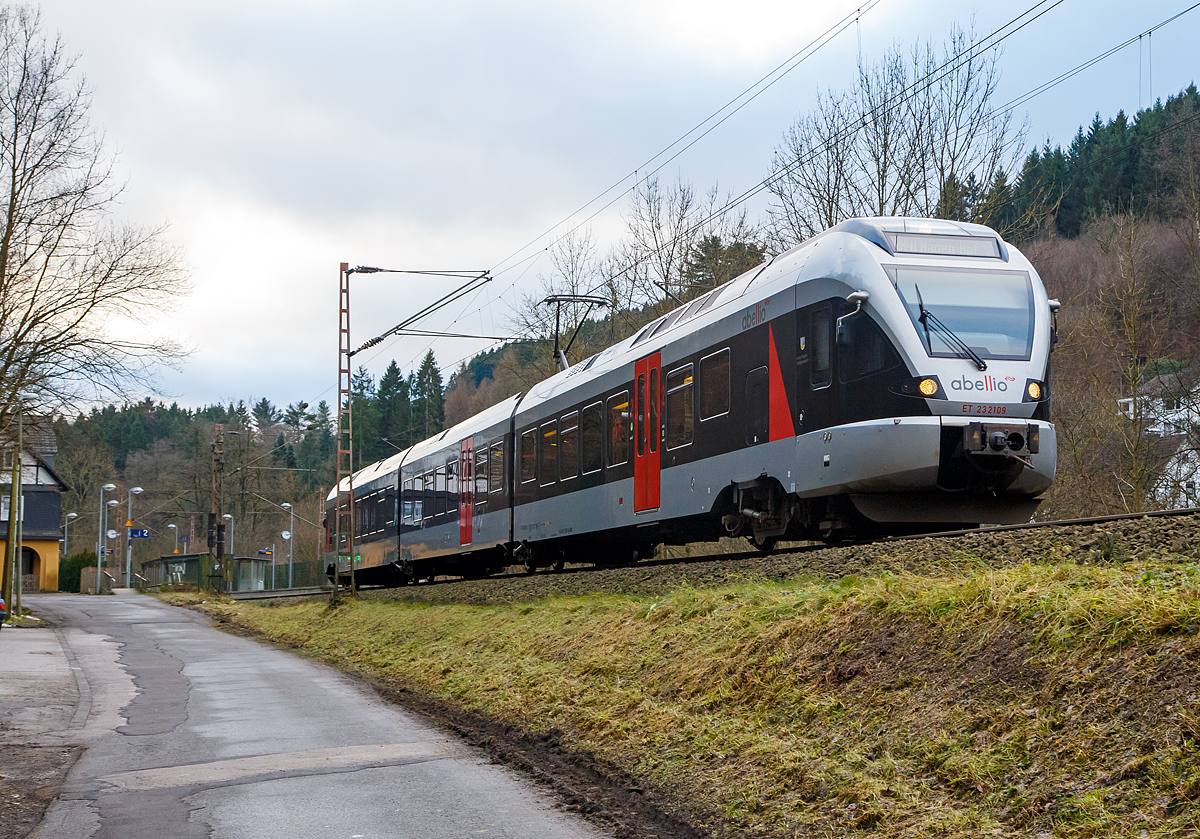 
Der 3-teiligen Stadler Flirt ET 23 2109  Kreis Siegen-Wittgenstein  der Abellio Rail NRW hat am 25.12.2017 gerade den Bf Kirchhundem verlassen und f�hrt als RB 91  Ruhr-Sieg-Bahn  (Siegen - Hagen) weiter in Richtung Hagen.

Er bef�hrt die Ruhr-Sieg-Strecke,  eine 106 Kilometer lange zweigleisige, elektrifizierte Hauptstrecke von Hagen nach Siegen �ber Iserlohn-Letmathe, Finnentrop und Kreuztal. Die tunnelreiche Strecke f�hrt �berwiegend durch das Tal der Lenne und s�dlich von Lennestadt-Altenhundem �ber die Wasserscheide zwischen Ruhr und Sieg.

Die DB plant ab dem Fahrplanwechsel 2019/2020 im Dezember 2019, eine Intercity-Linie von Frankfurt �ber Siegen und Iserlohn-Letmathe nach M�nster einzurichten. Ich pers�nlich finde das wird auch wieder Zeit, nach Einstellung der Interregio-Linie Frankfurt – M�nster (– teilweise bis Norddeich Mole) im Jahre 1993, und es waren immer gut gef�llte Z�ge. Zudem hoffe ich das die Halte, gegen�ber der RE 16, ausged�nnt werden.  

Leider auch nur ein Zwischenspiel bildete die Schnellzugverbindung (Mo-Fr)  mit dem D 810/811, die Dortmund mit Frankfurt in einer Reisezeit von unter drei Stunden verband, welche unterwegs nur in Siegen-Weidenau und Wetzlar hielt und aus hochwertigen, sonst nur in Intercity-Z�gen gef�hrten Wagen gebildet war. Diese war schneller als �ber Koblenz und entlang des Rheins. Da es von der Findigkeit des Kursbuchlesers abhing, diese prim�r f�r Gesch�ftsreisende konzipierte Verbindung zu ersehen, wurde sie bald wieder eingestellt.