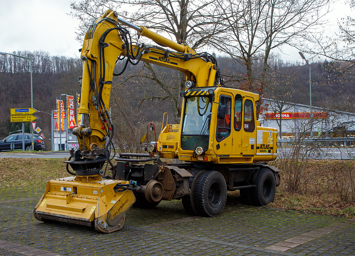  Der ATLAS-TEREX Zweiwegebagger 1604 ZW-WB mit Abst�tzpratzen, Kleinwagen Nr. D-WEBA 98 80 9901 683-9, der Westerwaldbahn des Kreises Altenkirchen GmbH ist am 07.02.2022, mit einem angebauten SEPPI Baggermulcher BMS 150 der HeringBau, in Betzdorf-Alsdorf auf einem Parkplatz neben Bahnstrecke Betzdorf–Daaden (Daadetalbahn) angestellt. 

Der Bagger wurde 2005 ATLAS-TEREX GmbH in Delmenhorst unter der Fabriknummer 168Z301630 gebaut.

TECHNISCHE DATEN des Baggers:
Spurweite: 1.435 mm
Achsabstand: 5.475 mm (Schiene) / 2.550 mm (Stra�e)
Eigengewicht: 22,2 t
Zul. Gesamtgewicht: 23.000 kg
Motorbauart: wassergek�hlter 4-Takt 4-Zylinder Diesel-Reihenmotoren mit Turboaufladung und Ladeluftk�hlung
Motortyp: Deutz BF 4M 2012 C
Motorhubraum: 4,04 Liter  (101mm / 126 mm Bohrung/Hub)
Motorleistung: 93 kW (127 PS) bei 2.500 U/min
H�chstgeschwindigkeit (Hg): 20 km/h (in Kreuzungen und Weichen 10 km/h)
Bremse: Dir.-Dbr. und Eisenbahnwagenbremsanlage
Zul. Anh�ngelast: 120 t
Zur Mitfahrt zugel. Personenzahl: 1 (und Fahrer)
Antrieb auf Schiene: �ber Reibantrieb der Stra�enreifen

Der angebaute Mulcher:
Der SEPPI BMS 150 ist ein leistungsvoller Forstmulcher. Dieser SEPPI Baggermulcher BMS mulcht (zerkleinert Holz) Stubben und St�mme bis zu 30 cm Durchmesser. Die Arbeitsbreite bei diesem BMS 150 betr�gt 150 cm, das Gewicht betr�gt 1.400 kg. Hersteller ist die SEPPI M. AG in Kaltern (S�dtirol) – Italien.
 
