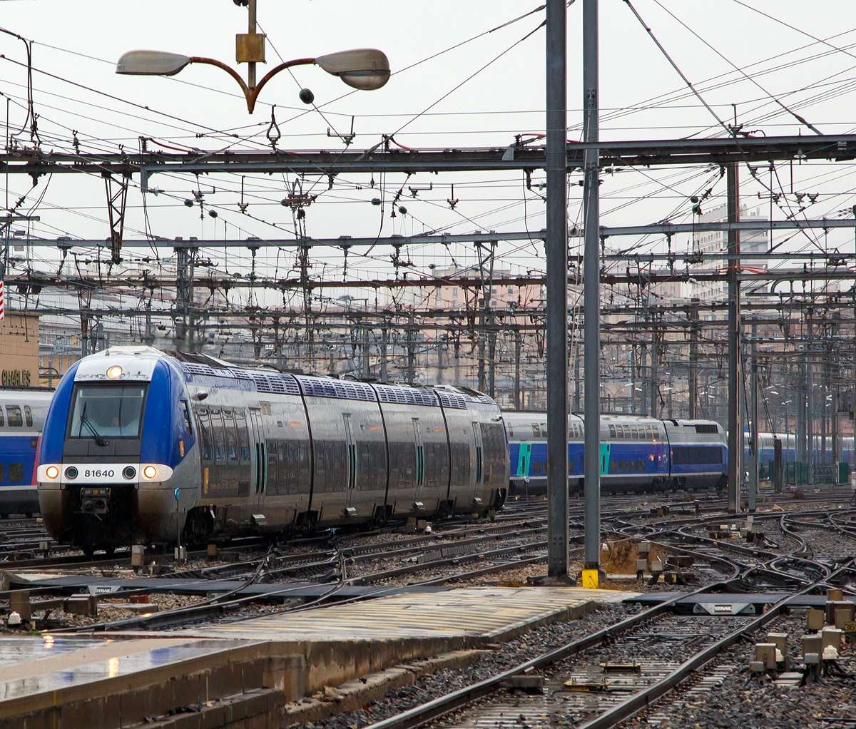 
Der  B 81640 / B 81639 ein vierteiliger Hybrid BGC-AGC-Triebzug (bimode) der SNCF TER Provence-Alpes-Côte d'Azur fährt am 25.03.2015 in den Bahnhof Marseille Saint-Charles ein. 

Die SNCF-Baureihe B 81500 Zweikraftversion (BGC / bimode) des autorail à grande capacité (AGC) des Herstellers Bombardier, sie können sowohl mit Dieselantrieb als auch elektrisch unter 1,5 kV Gleichspannung fahren. Den B 81500 gibt es als dreiteiligen und vierteiligen Zug. Ein Triebzug jeweils zwei angetriebene Enddrehgestelle, die dazwischen liegenden Drehgestelle sind Jakobs-Drehgestelle. Der Autorail Grande Capacité kurz AGC (deutsch: „Triebwagen mit großer Kapazität“) ist ein Triebzug der von Bombardier in Crespin für die SNCF gebaut wurde. 