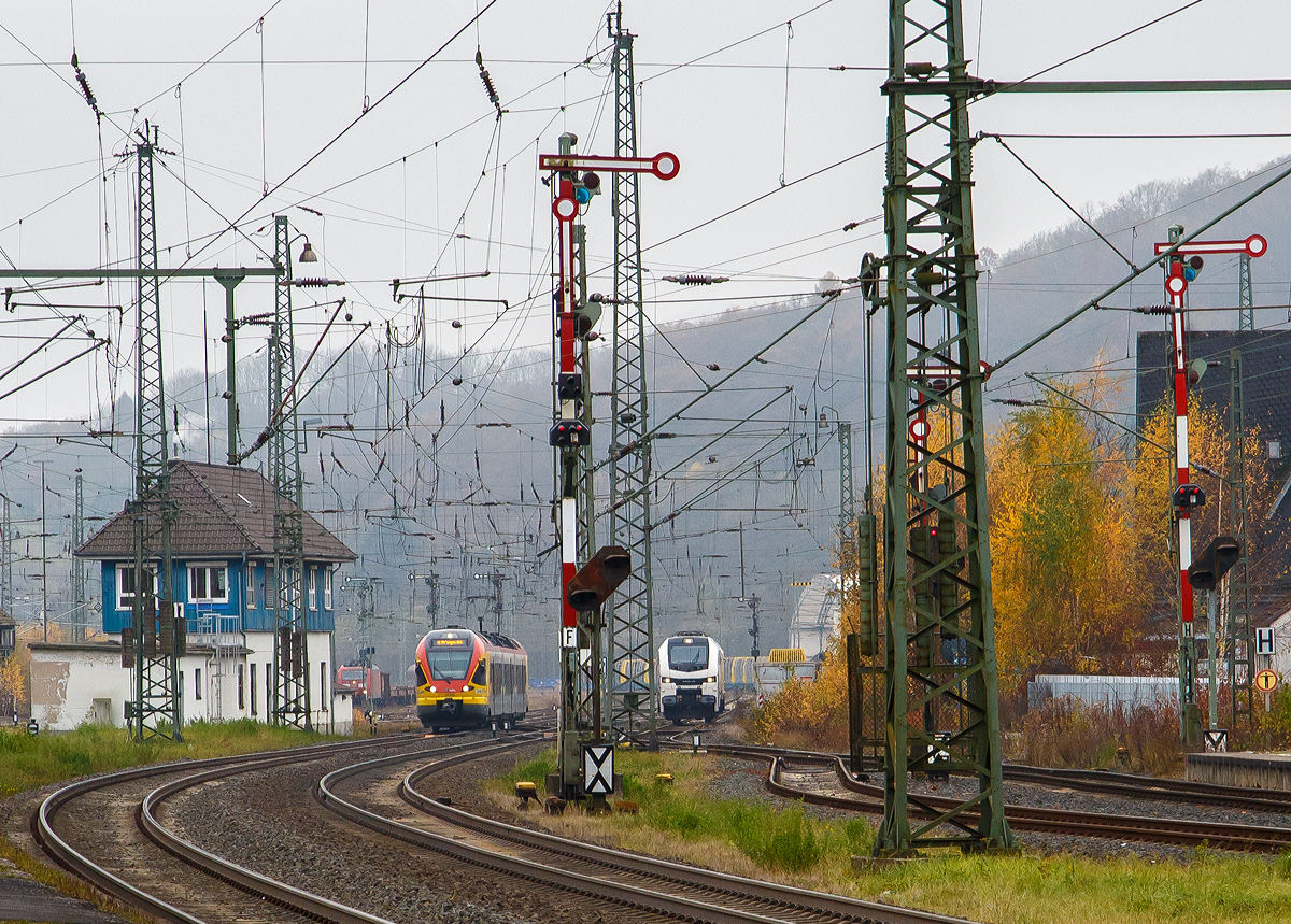 Der Bahnhof Dillenburg an dem diesigen 12.11.2021, Blickrichtung Rbf (Süden):
Im Rbf ist z.Z. eine mächtige Holzverladung (Fichtenholz) im Gange. Links das Stellwerk Dillenburg Fahrdienstleiter (Df) , rechts davon kommt gerade 3-teilige Stadler FLIRT 427 042 / 827 042 / 427 542 der HLB Bahn, als RE 99 Gießen – Siegen (unser Zug). In der Bildmitte rangiert gerade eine an die HLG - Holzlogistik und Güterbahn GmbH vermietete Stadler EuroDual 6000 - BR 159.