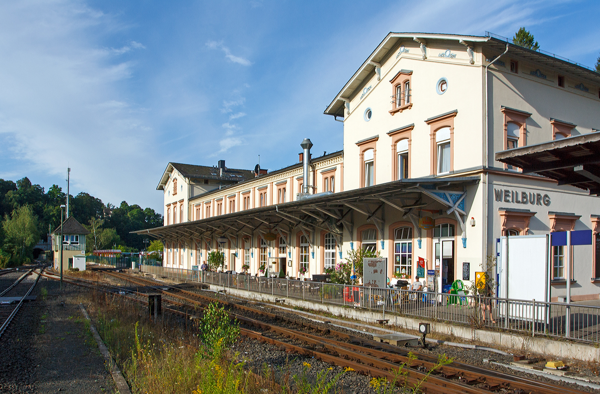 
Der Bahnhof Weilburg am 11.08.2014, Blick vom Bahnsteig. Ganz links im Bild das Nordportal von dem 302 m langem Weilburger Tunnel, etwas weiter rechts das Stellwerk Weilburg Fahrdienstleiter (Wf).

Der Bahnhof Weilburg ist ein Bahnhof in der mittelhessischen Stadt Weilburg. Der Bahnhof liegt an der Lahntalbahn. Von 1890 bis 1988 zweigte unmittelbar hinter dem Bahnhof die Weiltalbahn Richtung Weilmünster ab.

Erbaut wurde der Bahnhof Weilburg zunächst als Endbahnhof der Lahntalbahn im Zuge der Eröffnung der Teilstrecke zwischen den Bahnhöfen Limburg (Lahn) und Weilburg, welche am 14. Oktober 1862 in Betrieb genommen wurde.

Am 1. November 1891 wurde die Weiltalbahn von Weilburg bis Weilmünster eingeweiht. Nachdem die Fortsetzung bis Usingen am 1. Juni 1909 in Betrieb genommen war, konnten die Züge – zeitweise auch Eilzüge – von Weilburg bis Frankfurt am Main durchfahren. Weilburg wurde zum Verkehrsknotenpunkt und Umsteigebahnhof. Diese Verbindung endete, als am 27. September 1969 der Personenverkehr zwischen Weilmünster und Weilburg eingestellt wurde. Auf diesem Teilstück wurde noch bis zum 30. Januar 1988 Güterverkehr im Übergabeverfahren betrieben. Danach verlor der Bahnhof Weilburg seine Funktion als Knotenpunkt im Güterverkehr.

Vor dem Hessentag in Weilburg 2005 wurde der Mittelbahnsteig im Weilburger Bahnhof erneuert und behindertengerecht umgebaut. Der zusätzliche Behelfsbahnsteig zum Hessentag wurde anschließend wieder entfernt.

Das denkmalgeschützte Empfangsgebäude wurde als spätklassizistischer Bau von Heinrich Velde konzipiert und ähnelt den Bahnhofsgebäuden von Leun/Braunfels und Diez, die ebenfalls aus seinen Entwürfen entstammen. Zwischen giebelständigen, erhöhten Kopfbauten befindet sich ein traufständiger Trakt mit vorgelagerter Pultdachhalle, die nach der Zerstörung im Krieg vereinfacht wieder errichtet wurde. Die Gesimsbänder sowie die Giebel verfügen über Schmuckmotive. 

Heute befindet sich in dem Empfangsgebäude das Hotel-Restaurant Lahnbahnhof.

