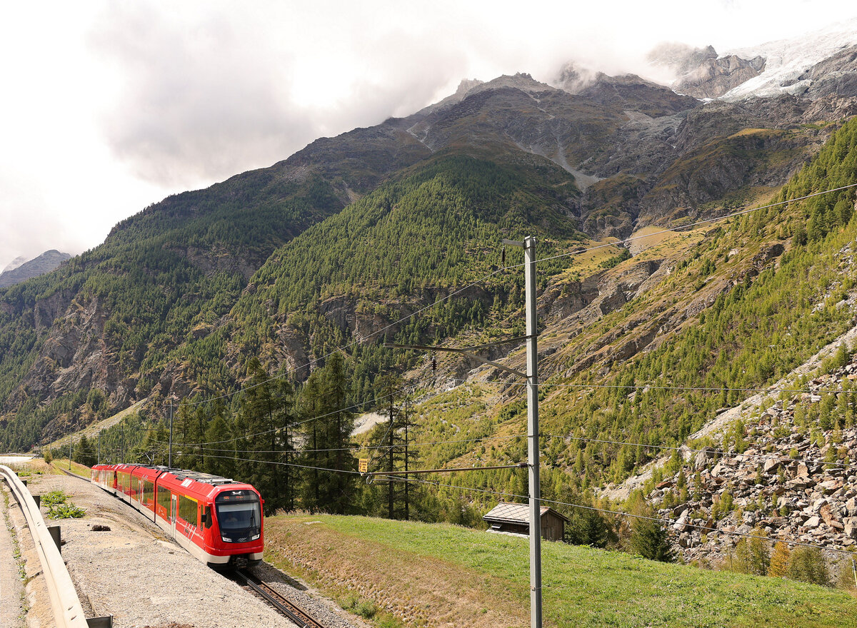 Der Bergsturz von Randa: Auf der Fahrt talabwärts haben die Orion-Züge 310 und 305 die starke Steigung von Randa herauf zum Scheitelpunkt der Umfahrung bewältigt und fahren nun zum steilen Abstieg talauswärts. Oben wieder der absturzgefährdete Bisgletscher. 30. August 2025 
 