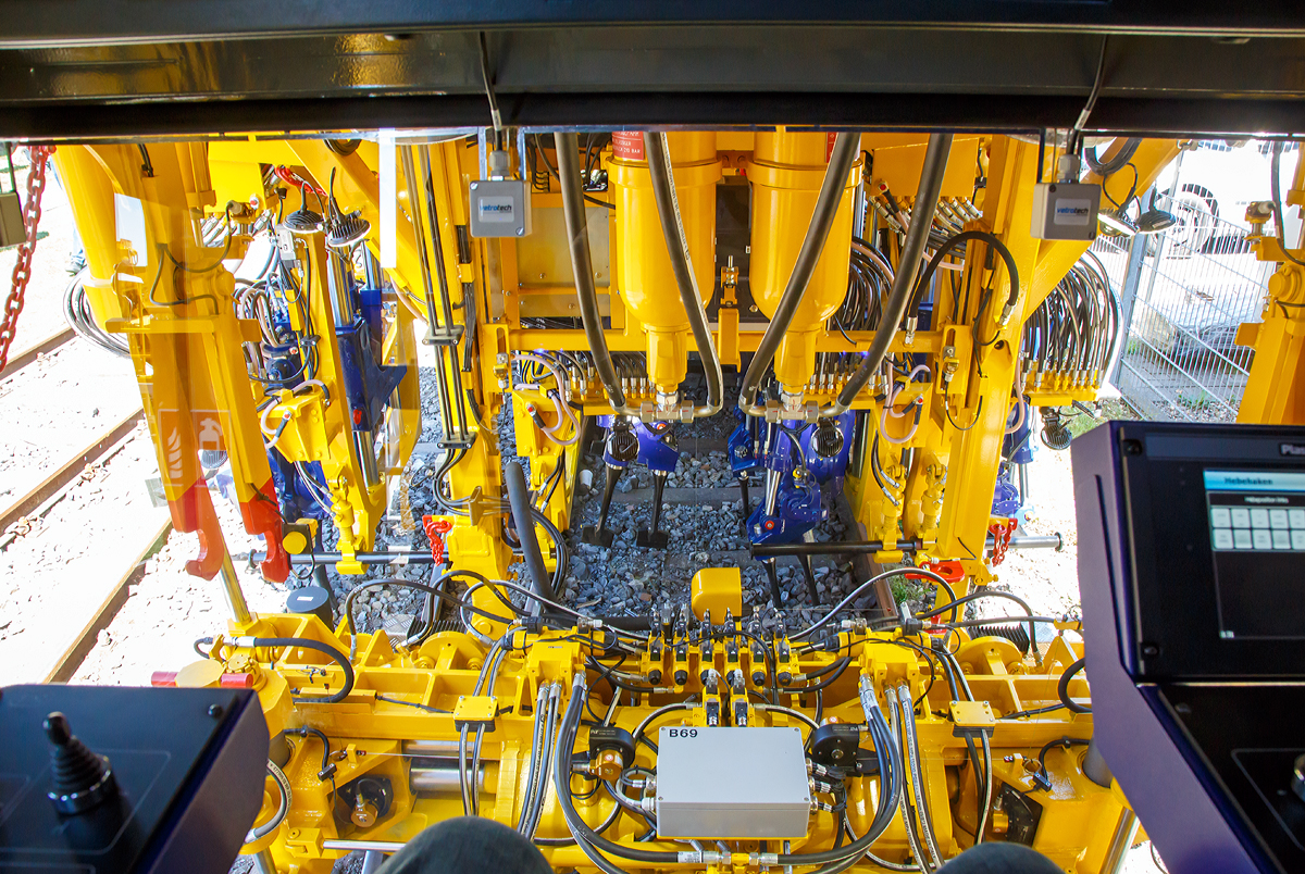 
Der Blick des Maschinenführers auf das Stopfaggregat der Plasser & Theurer  UNIMAT 09-4x4/4S E3 ATW (A-PLA 99 81 9124 004-8),  eine Universal-Weichenstopfmaschine mit Hybrid-Antriebstechnik, der Franz Plasser Vermietung von Bahnbaumaschinen GmbH präsentiert auf der iaf 2017 in Münster (am 01.06.2017). Man sieht sehr viele Hydraulikschläuche.