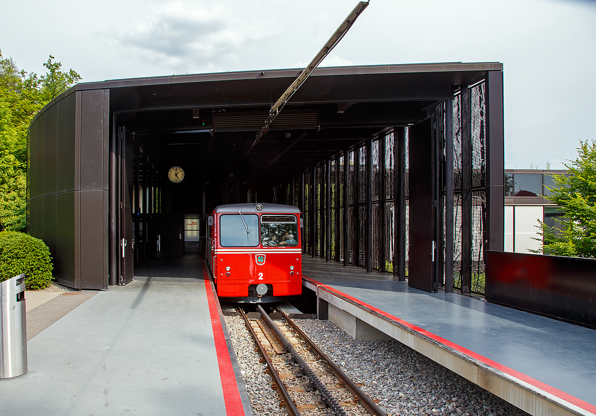 Der elektrischer Zahnradtriebwagen Bhe  1/2 Nr. 2 der Dolderbahn steht am 06.06.2015 in der Bergstation zur Talfahrt bereit

Die beiden Elektrischer Zahnradtriebwagen Bhe  1/2 der Dolderbahn
Im Jahr 1972 stellte die Dolderbahn- Betriebs AG den Seilbahnbetrieb ein, verlängerte die Strecke um rund 500 m auf 1,3 km und verlegte eine Lamellenzahnstange (System von Roll) in das erneuerte Gleis. Für den Zahnradbetrieb lieferte die SLM 1973 zwei zweiachsige Zahnradtriebwagen. Jeder dieser Zahnradtriebwagen hat talseitig eine Triebachse und bergseitig eine Bremsachse. Ein im Untergestell in Längsrichtung angeordneter Fahrmotor treibt über eine Kardanwelle und ein zweistufiges Getriebe das Triebzahnrad an. Die Verbundbauweise des Wagenkastens mit dem Untergestell ergibt eine selbsttragende, leichte und solide Konstruktion.  Volle Betriebssicherheit wird durch eine elektrische Widerstandsbremse, eine Zahnradbremse sowie eine Klinkenbremse gewährleistet.

TECHNISCHE DATEN:
Hersteller: SLM (Schweizerische Lokomotiv- und Maschinenfabrik), Winterthur
Elektrischen Ausrüstung: BBC (Brown, Boveri & Cie. AG), Baden
Spurweite: 1.000 mm (Meterspur)
Zahnstangensystem: von Roll
Achsformel: 2z
Max. Steigung: 196 ‰
Länge über Puffer: 11.520 mm
Achsabstand: 5.400 mm
Laufraddurchmesser: 690 mm
Teilkreisdurchmesser Treib- und Bremszahnrad: 573 mm
Eigengewicht: 14,4 t
Max. Zuladung: 7,8 t
Leistung: 131,5 kW (dauernd) / 149,5 kW (einstündig)
Zugkraft: 22,9 kN (dauernd) / 27,2 kN (einstündig)
Höchstgeschwindigkeit: 25 km/h (Bergfahrt) / 16 km/h (Talfahrt)
Getriebeübersetzung: 1 : 10,45
Sitzplätze: 26
Stehplätze: 74
Fahrdrahtspannung: 600 V = (DC)

Die Dolderbahn ist eine Privatbahn in der Stadt Zürich. Die Zahnradbahn erschließt das Dolder-Gebiet im Quartier Hottingen ab der Haltestelle Römerhof am Römerhofplatz auf 444 Metern über Meer und endet in der Station Dolder auf dem Adlisberg auf 606 Metern über Meer. Die Bahn dient nebst der Verbindung mit dem Wohnquartier auch als Zubringer für zwei Hotels, dem Wellenbad Dolder, der offenen Eisbahn Dolder und dem als Naherholungsgebiet dienenden Adlisberg.

Die Betreibergesellschaft wurde 1893 gegründet. 1895 wurde der Betrieb als Standseilbahn aufgenommen. Sie führte auf einer Strecke von rund 800 Metern vom Römerhofplatz zum Hotel Waldhaus Dolder auf 548 Metern über Meer.

Zur Verbindung mit dem Grand Hotel Dolder wurde am 5. Juli 1899 ein meterspuriges Tram in Betrieb genommen. Es wurde mit einem einzigen Wagen gleicher Bauart wie die StStZ-Wagen 57–84 betrieben. Die Strecke hatte keine direkte Verbindung zum Zürcher Tramnetz, jedoch sorgte die StStZ für den Unterhalt des Motorwagens und stellte während einer längeren Revision einen Ersatzwagen. Am 31. Dezember 1930 wurde das Dolder-Tram eingestellt und ein Bus übernahm die Verbindung zwischen Waldhaus und Grand Hotel.

Zwischen 1972 und 1973 wurde die Standseilbahn durch eine Zahnradbahn ersetzt und die Strecke bis zum Grand-Hotel Dolder verlängert. Weil dazu eine Kurve nötig war, wurde aus der Seil- eine Zahnradbahn. Seither misst sie 1.328 Meter und überwindet dabei eine Höhendifferenz von 162 Metern mit einer Neigung von maximal 19,6 Prozent. Weitere Vorteile gegenüber einer Standseilbahn sind, die Bahntrasse kann besser dem Gelände angepasst werden, die Ausweichstelle muß nicht genau in der Mitte der Bahnstrecke liegen. Zudem ist ein Einwagenbetrieb oder ein späterer Ausbau für automatischen Betrieb möglich.