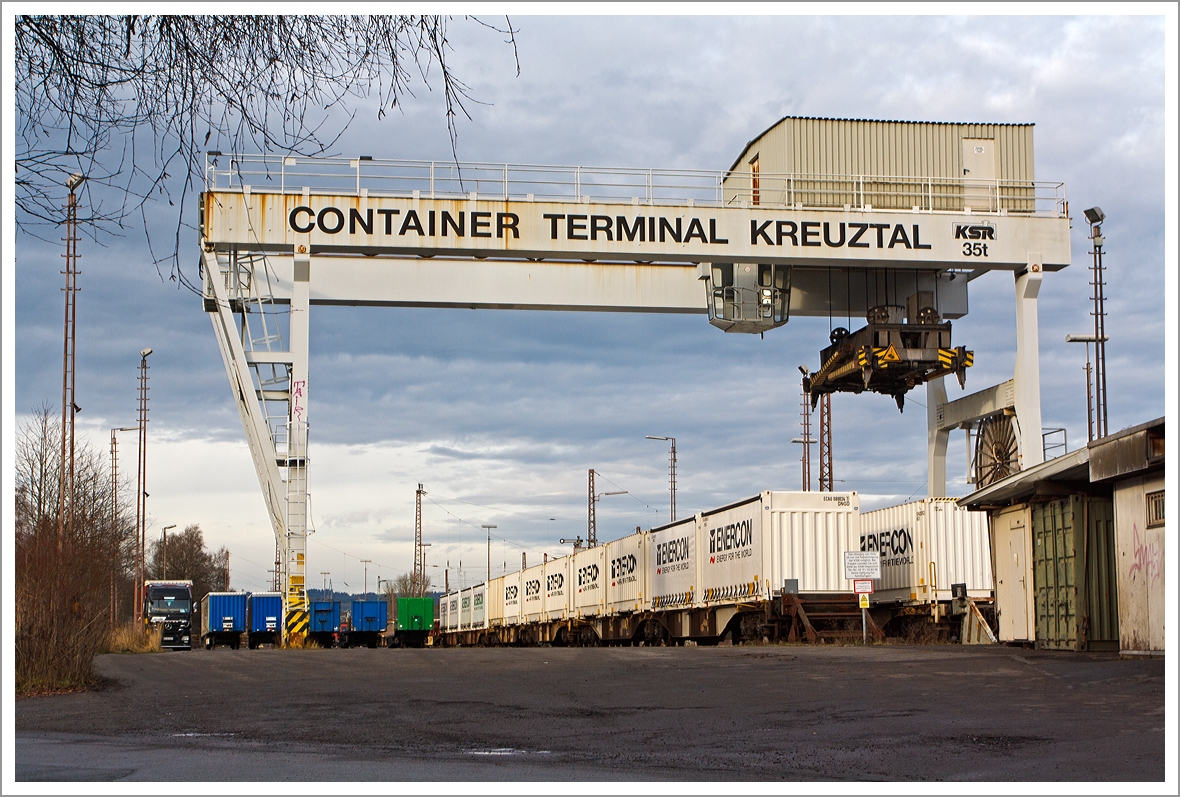 
Der Kran geh�rt bald zum alten Eisen....

Noch ist der Blick frei auf das Container-Terminal Kreuztal, hier am 21.12.2013. Eigent�mer von dem Terminal ist KSW Kreisbahn Siegen Wittgenstein GmbH, die dieses 1996 von der DB Cargo erworben hat. Das zurzeit nur wenig genutzte Container-Terminal Kreuztal soll sich in K�rze in den wichtigsten G�terumschlagplatz der Region verwandeln.

Um das Container-Terminal in einen solchen zentralen Verladebahnhof zu verwandeln, wird bald einiges geschehen. Das rund 15 000 Quadratmeter gro�e Areal wird umgestaltet. Zwei Umschlaggleise und ein Abstellgleis m�ssen geschaffen, die Stra�e muss teilweise verlegt werden.

Der nicht mehr zeitgem��e Portalkran wird verschwinden, da k�nftig zwei gro�e Gabelstapler, sog.  Reach Stacker , das Verladen �bernehmen. Rund 10,3 Mill. Euro soll der Ausbau des Drehkreuzes kosten, 85 Prozent davon sollen aus einem F�rdertopf gesch�pft werden.

Weil man strebt eine Betriebszulassung von 24 Stunden f�r das Container-Terminal an. Daf�r wird die KSW das Areal mit stattlichen L�rmschutzw�nden ein hausen m�ssen, die insgesamt etwa 370 Meter lang und bis zu 13 Meter hoch sein werden.

Heute ist es das S�dwestfalen Container-Terminal GmbH (SWCT).
