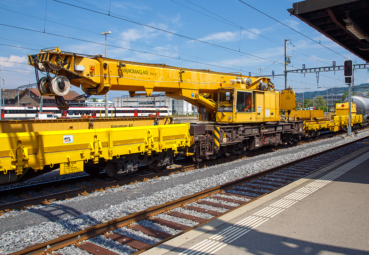 Der Kran V der Vanomag AG ein 100 t GOTTWALD Gleisbauschienenkran GS 80.08 T, 99 85 9219 025-5 CH-VMG VTmaass, ex VTmaass 80 85 95 81 404-3, im Zugverband am 18.05.2018 beim Signalhalt im Bahnhof Yverdon-les-Bains.

Der Kran wurde 1994 von Gottwald in Düsseldorf gebaut.

TECHNISCHE DATEN:
Spurweite: 1.435 mm
Länger über Puffer: 13.000 mm (ohne Kranausleger)
Breite in Transportstellung:  3.100 mm
Höhe in Transportstellung:  4.200 mm
Anzahl der Achsen: 8 (in 4 Drehgestelle bzw. 2 Doppeldrehgestelle)
Drehzapfenabstand: 8.000 mm
Drehzapfenabstand im Doppeldrehgestell: 2.300 mm
Achsabstand in den Einzeldrehgestellen: 1.100 mm
Ergebene Achsabstände in m: 1,1 / 1,2 / 1,1/ 5,6 / 1,1 / 1,2 / 1,1
Raddurchmesser: 730 mm (neu) / 680 mm (abgenutzt)
Eigengewicht (in Transportstellung): 120 t
Maximale Traglast: 100 t (abgestützt)  / 80 t (freistehend)
Kleinster befahrbarer Radius: 90 m 
max. Geschwindigkeit im Zugverband: 120 km/h
max. Geschwindigkeit im Eigenantrieb: 20 km/h
Maximale Achslast (in Transportstellung): 15 t
Motorleistung  190 kW
Maximale Ausladung vor Puffer: 13,5 m (Traglast 30 t)