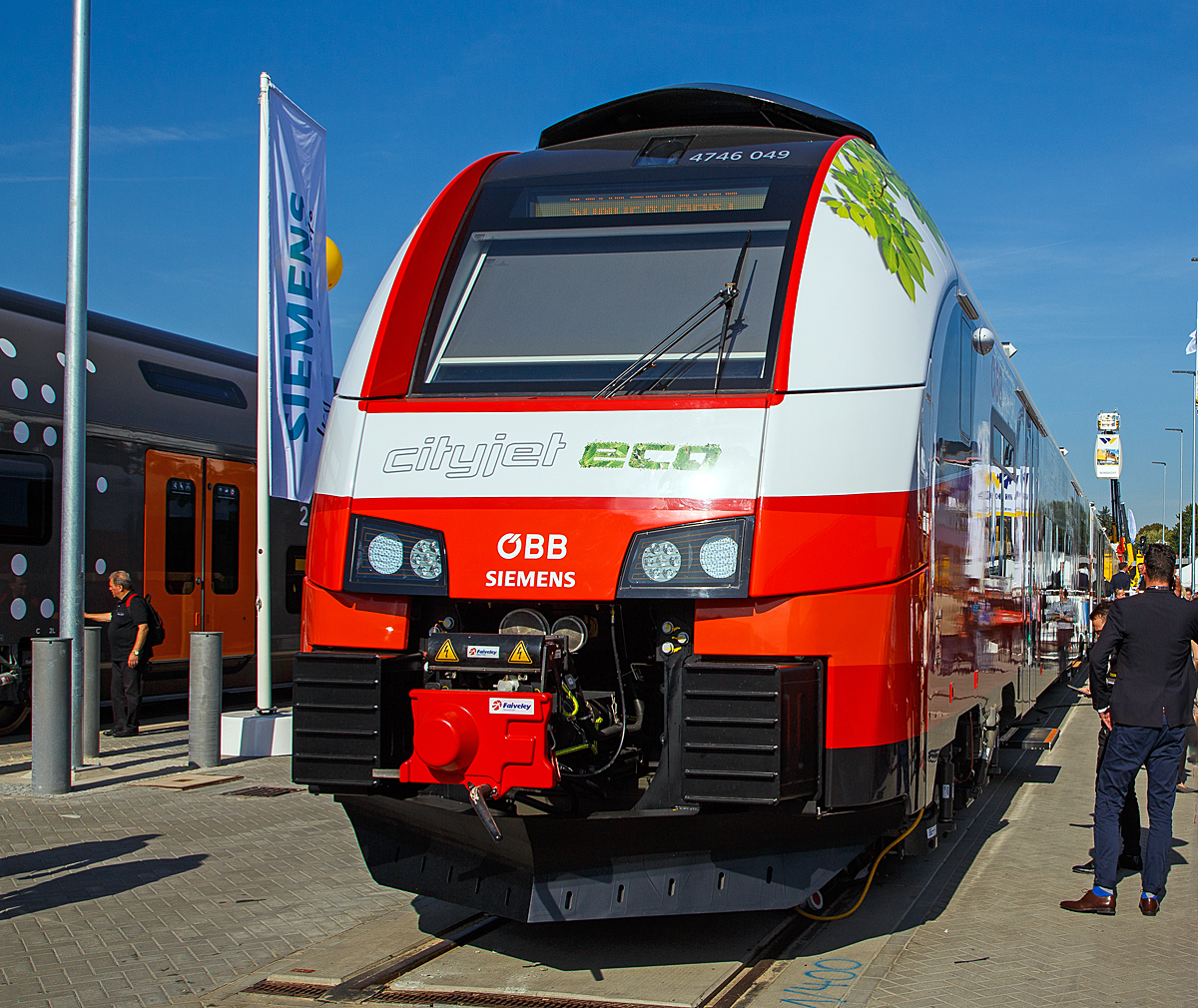 
Der ÖBB Cityjet eco eine Innovation auf Schiene....
Siemens und ÖBB präsentierte auf der InnoTrans 2018 in Berlin (hier 18.09.2018) mit dem ÖBB 4746 049 den Prototyp ÖBB Cityjet eco, ein elektro-hybriden Siemens Desiro ML, eine Innovation auf der Schiene.

ÖBB und Siemens setzen mit dem Cityjet eco neue Maßstäbe auf nicht-elektrifizierten Strecken im Nah- und Regionalverkehr. Mit diesem Zug kann künftig eine nachhaltige Alternative zu Dieselfahrzeugen abseits der Hauptverkehrsrouten geboten werden.

Der Cityjet eco ist eine Alternative für nicht-elektrifizierte Strecken, die heute größtenteils mit dieselbetriebenen Personenzügen befahren werden. Siemens entwickelt einen elektro-hybriden Batterieantrieb, der es möglich macht, dass der Zug auf elektrifizierten Strecken Energie über seinen Stromabnehmer aufnimmt und gleichzeitig in den neu mitgeführten Batterien speichert. Diese Energie kann für den Betrieb auf nicht-elektrifizierten Strecken genutzt werden. Sobald der Zug die elektrifizierte Strecke verlässt, speisen die Batterien das Energieversorgungssystem des Zuges (bis zu ca.80 km). Gemeinsam mit den ÖBB wird diese Technologie nun in einem Pilotprojekt in den kommenden Monaten in der Praxis auf Herz und Nieren geprüft und zur Serienreife weiterentwickelt.

Das Pilotprojekt wird mit einem Zug aus der aktuell für die ÖBB laufenden Serienproduktion des Siemens Desiro ML umgesetzt. Die Bauweise des Fahrzeuges ermöglicht es, zusätzliche Dachlasten aufzunehmen. Damit sinkt die ansonsten branchenweit übliche Liefer- und Fertigungszeit eines Neufahrzeugs von bis zu 36 Monaten auf weniger als die Hälfte.

Die laufende Serienfertigung des ÖBB Cityjets eröffnete die Möglichkeit einer kurzfristigen Entnahme eines Fahrzeugs sowie dessen Umbau zu einem Akku-Triebzug und kurzfristigen Einsatz als Prototypzug im Rahmen einer Erprobungsphase. Die Batterieanlage am Mittelwagen des umgebauten Triebfahrzeuges ÖBB 4746 049 / 549 der Serie DESIRO ML umfasst drei Batteriecontainer, zwei DC/DC-Steller, einen Batteriekühler sowie weitere Elektronikbauteile. Zum Einsatz kommen Lithium-Titanat-Batterien (LTO-Technologie). Diese modifizierten Batterien erlauben – verglichen mit herkömmlichen Lithium-Ionen-Batterien – deutlich höhere Ladeströme zur Schnellladung. Die Lebensdauer der Batterien soll bei Serienreife rund 15 Jahre betragen, was zur Folge hätte, dass sie über die Gesamtnutzungsdauer des Zuges nur einmal gewechselt werden müssen.

TECHNISCHE DATEN:
Spurweite:1.435 mm
Achsfolge: Bo‘Bo‘+2‘2‘+Bo‘Bo‘
Länge (über Kupplung): 75.152 mm
Drehzapfenabstand: 16.240 mm
Achsabstand im Drehgestell: 2.300 mm
Antriebsleistung: 2.600 kW (ca. 1.300kW im Batterie-Modus)
Höchstgeschwindigkeit: 140 km/h (120 km/h im Batterie-Modus)
Installierte Batteriekapazität: 528 kWh
Anfahrbeschleunigung1,0 m/s² (0.77 m/s² im Batterie-Modus)
Stromsystem: 15 kV 16,7 Hz AC / 25 kV, 50 Hz AC
Fußbodenhöhe: 600 mm
Fahrgastkapazität: 244 Sitzplätze 
Max. Achslast: kleiner 17 t 
