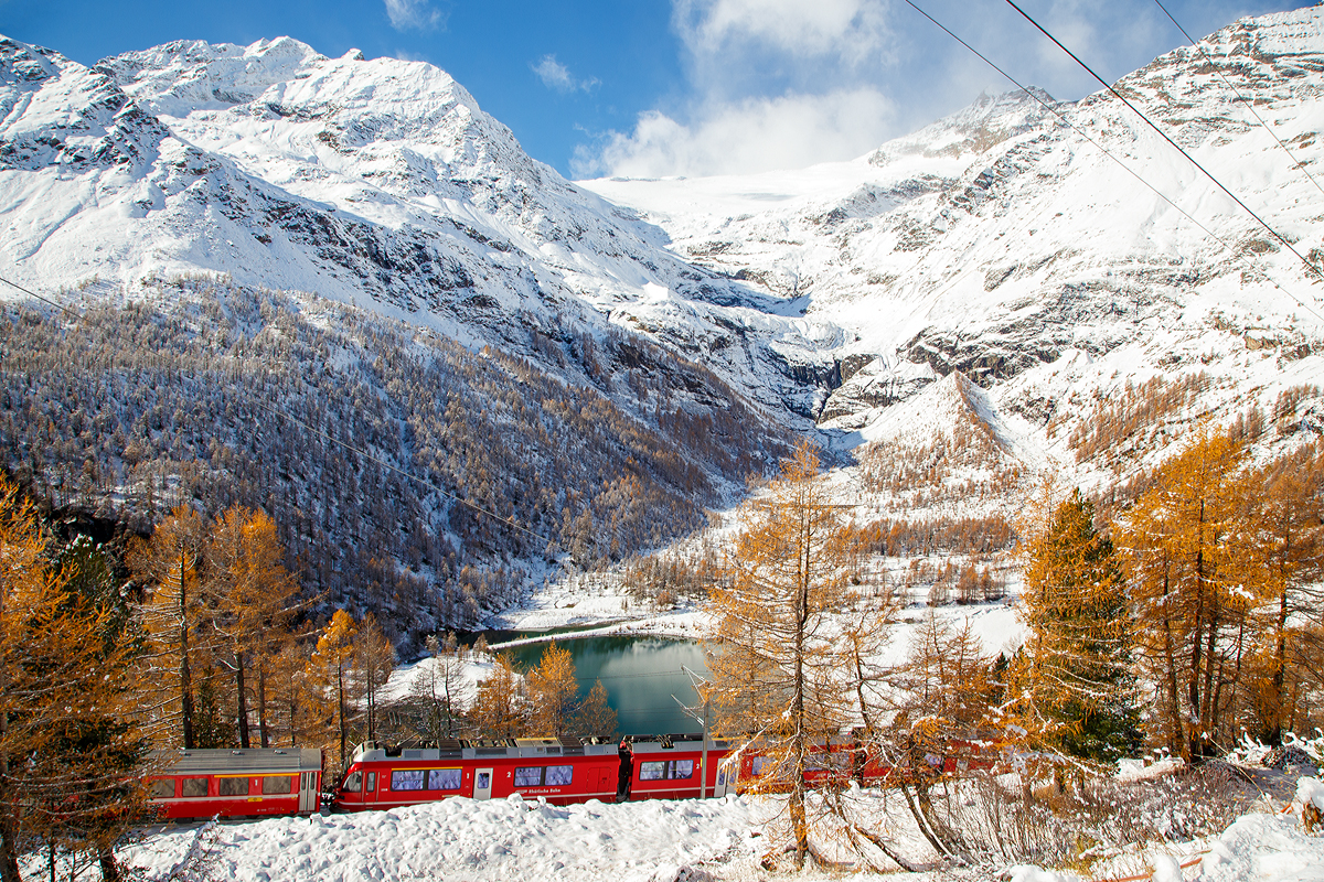 
Der RhB ALLEGRA-Zweispannungstriebzug (RhB  ABe 8/12) 3508  Richard Coray  mit 2 angehangenen Personenwagen als Regio-Zug nach Tirano fährt am 04.11.2019 von Alp Grüm nun hinab in Richtung Tirano. 

Unten der Lago Palü (Lagh da Palü, dt. Palüsee) am Fuße des Piz Palü. Der See wird größtenteils vom Palügletscher gespeist, den man (heute nur noch) oben in der Bildmitte erahnen kann.
