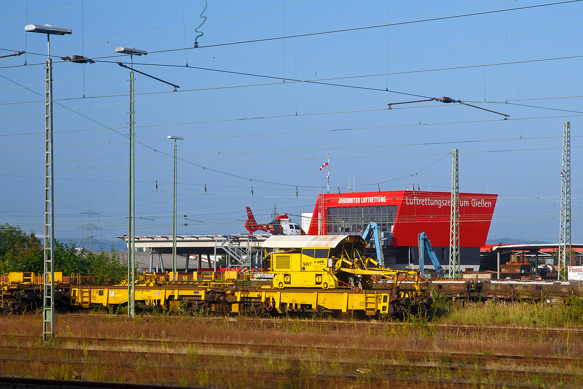 Der Schienenladewagen SLW 7, Schweres Nebenfahrzeug Nr. 97 30 08 907 57-6, der Vossloh Mobile Rail Services GmbH abgestellt mit Lanschienentransport am 05.09.2021 beim Bahnhof Gießen. Aufgenommen aus einem Zug heraus.

Der Schienenladewagen wurde 2007 von Maschinen- und Anlagenservice MAS GmbH in Guben unter der Fabriknummer 01/07 gebaut, wobei der Schienenmanipulator von Robel stammt und überarbeitet wurde. Das Eigengewicht beträgt 47 t, die Höchstgeschwindigkeit 120 km/h und der kleinste befahrbare Gleisbogen 80 mm.

Der Schienenladewagen dient zum Be- und Entladen von bis 180 m langen Schienen, auf/von den Schwellenköpfen bzw. in/aus Gleismitte. Der Einsatz erfolgt in Kombination mit Langschienentransporteinheiten der Bauart Robel. Die Be- bzw. Entladeleistung beträgt ca. 900 bis 1.400 m Gleis/Stunde.