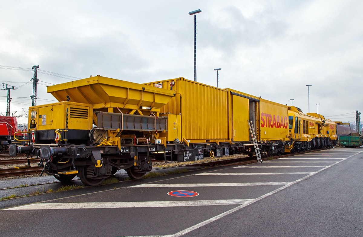 
Der Strabag „Hannibal“ ein LINSINGER Schienenfräszug SF 03 W-FFS, Schweres Nebenfahrzeug Nr. 99 80 9427 003-5 D-BRS der BMTI Rail Service GmbH (Servicebetrieb der STRABAG SE) steht am 01.12.2017, mit dem Beiwagen „Vogel der Nacht“ der Gattung Res 37 80 3999 115-3 D-BRS, beim ICE-Bahnhof Montabaur. Hier bereitet die Tagschicht das Fahrzeug für neue Aufgaben vor und lässt die Späne in einen Abrollcontainer ablaufen.

Auch hochwertige Gleise unterliegen den „normalen“ Verschleißprozessen. Um die Betriebssicherheit, die Betriebskosten und den Fahrkomfort dauerhaft zu gewährleisten und gering zu halten, müssen sie in regelmäßigen Abständen wieder „in Form“ gebracht werden bzw. der Schienenkopf reprofiliert werden. Damit der Aufwand und die betrieblichen Störungen für das Reprofilieren gering gehalten werden kann, werden diese hochmodernen Fräszüge eingesetzt. Die Bearbeitungsgeschwindigkeit liegt bei 8 bis 25 m/min, je dem wie viel abgefräst werden muss. Die Bearbeitungsgenauigkeit liegt bei:
Querprofilgenauigkeit +/- 0,1 mm
Längsprofilgenauigkeit 0,05 mm
Oberflächenqualität Ra = ca. 3µm

Weitere Vorteile des Fräsens sind:
Kein Funkenflug bei der Bearbeitung
0,3 - 3 mm Frästiefe in einem Durchlauf bzw. Überfahrt
Fahrkante als Bezugskante wählbar
Höhenkopierung zur Minimierung der Längswelligkeit
Profilform durch unterschiedliche Fräsformwerkzeuge änderbar
Bearbeitungsgeschwindigkeit bis zu 25 m/min
Abrollgeräusch des Rades auf der Schiene unter 46 dbA

Technische Daten das Fräszuges 99 80 9427 003-5 D-BRS:
Bauart: SF 03 W-FFS
Hersteller: LINSINGER Maschinenbau Ges. m.b.H., Steyrermühl, Österreich
Fabriknummer: OLJ-001
Baujahr: 2010
Spurweite: 1.435 mm (Normalspur)
Achsformel: Co´Co´
Länge über Puffer: 23.800 mm
Drehzapfenabstand: 15.300 mm
Leistung: 675 kW
Eigengewicht: 112,2 t
Nutzlast: 5,8 t
Radsatzfahrmasse: 20 t
Höchstgeschwindigkeit: 100 km/h (Eigenantrieb oder geschleppt)
Zur Mitfahrt zugel. Personen: 5
Zulässige Anhängelast: 60 t
Zugelassen für Streckenklasse: CE und höher und CM4
Kleister befahrbarer Gleisbogen: R 150 m

Anzahl der Bearbeitungseinheiten (Fräseinheiten): links und rechts je 3 Stück
Durchmesser der Messerköpfe (Fräser): 600 mm
