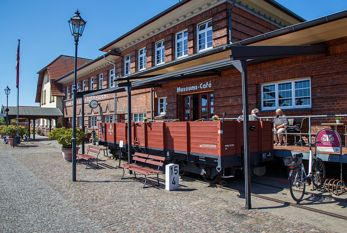 Der Terassenwagen, ein vierachsiger offener Güterwagen ex DR 98-02-55 der Gattung OOw, am Molli-Museums-Café beim Bahnhof Ostseebad Kühlungsborn-West (bis 1938 Ostseebad Arendsee) der Mecklenburgischen Bäderbahn Molli am 15.05.2022. Davor der Km-Stein (15,4 km) der Strecke.

Der Wagen wurde 1911 von der Waggonfabrik Wismar für die DHE - Doberan-Heiligendammer-Eisenbahn (ab 1. April 1920 zur Deutschen Reichsbahn), gebaut. Von 2005 bis 2006 wurde er rekonstruiert und dient seit 2006 als Terassenwagen des Molli-Cafes.

TECHNISCHE DATEN:
Spurweite: 900 mm
Gattung: OOw
Anzahl der Achsen: 4
Länge über Puffer: 8.800 mm
Drehzapfenabstand: 5.000 mm
Achsabstand im Drehgestell: 1.300 mm
Länge der Ladefläche: 8.000 mm
Ladefläche: 16 m²
Eigengewicht: 6.400 kg
Tragfähigkeit: 14,3 t
