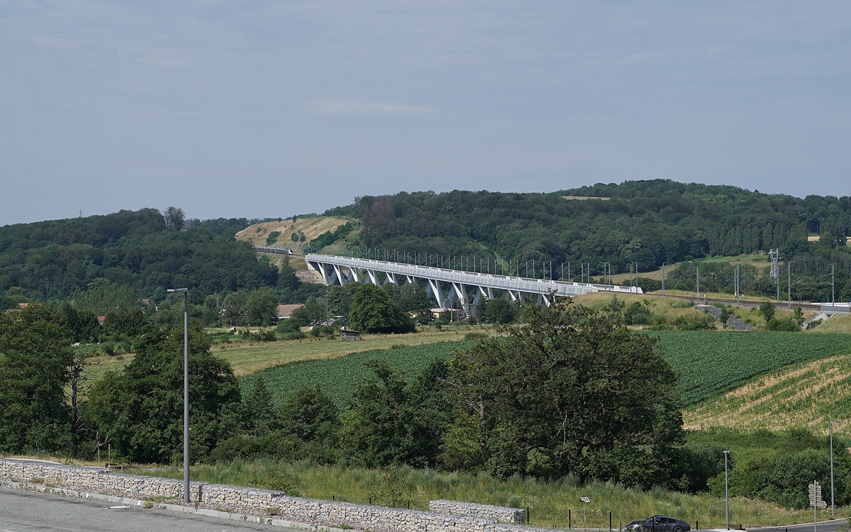 Der TGV 9881 von Luxembourg nach Montpellier hat den 816 Meter langen Savoureuse Viadukt hinter sich gelassen und fährt nun, kaum mehr zu sehen, weiter Richtung Dijon.

6. Juli 2019