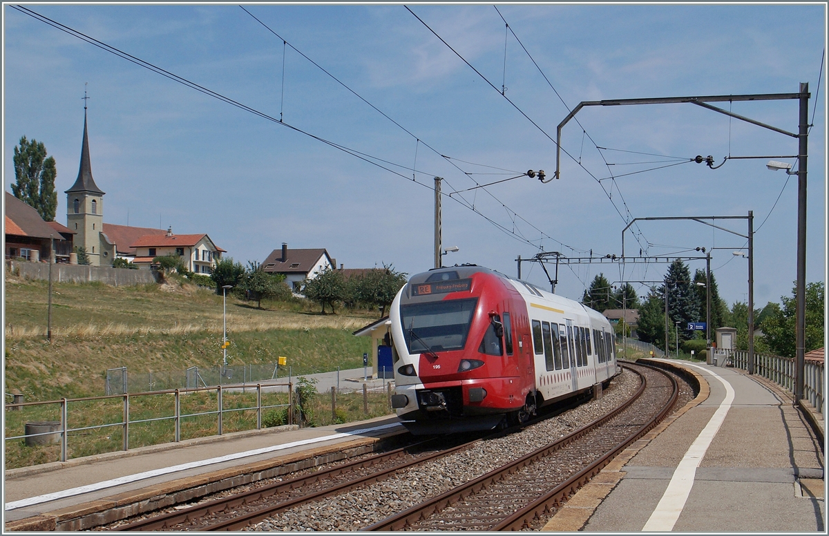 Der TPF RABe 527 195 fährt durch die Haltestelle Neyruz.
6. August 2015