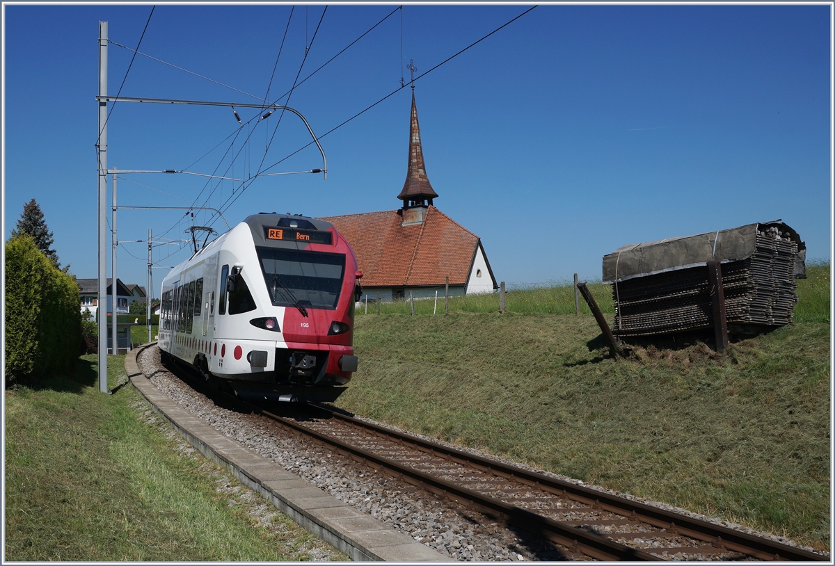 Der TPF RABe 527 195 ist bei Vaulruz auf dem Weg nach Bern, rechts im Bild , die hier typischen an den Gleisböschung stehenden Bretterstapel.

19. Mai 2020