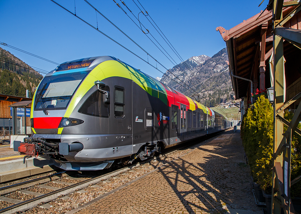 Der Trenitalia ETR 170 103, ein sechsteiliger Stadler FLIRT (MS für I / A) hat am 27.03.2022, als Regionalzug von Brenner/Brennero via Bozen/Bolzano nach Meran/Merano, den Bahnhof Gossensaß/Colle Isarco erreicht.

Diese sechsteiligen Elektrotriebzüge vom Typ Stadler FLIRT wurden für den grenzüberschreitenden Verkehr zwischen Italien und Österreich konzipiert. Die 160 km/h schnellen Züge werden auf den Linien Meran-Bozen-Brenner, Unterland Trento-Ala und Franzensfeste-Innichen-Lienz (Pustertal) eingesetzt. Die aktuelle Flotte besteht derzeit aus 25 FLIRTs. Sie sollen auch noch im Vinschgau (Meran-Mals), unter 25 kV 50 Hz, eingesetzt werden. Sie sind mit dem Zugsicherungssystem ETCS ausgestattet. Die Flachbautechnik ermöglicht den direkten Einstieg ohne Podest. Der klimatisierte Innenraum und das offene und transparente Design machen die Reise mit angenehm für die Passagiere. Ein modernes Informationssystem versorgt die Fahrgäste mit allen notwendigen Informationen, sie sind zudem mit WLAN ausgestattet.

TECHNISCHE DATEN:
Bezeichnungen: ETR 170 (6-Teiler)
Spurweite:  1.435 mm (Normalspur)
Achsformel: Bo’ 2’2’2’2’2’ Bo’
Länge über Kupplung:106.578 mm 
Fahrzeugbreite: 2.800 mm
Fahrzeughöhe: 4.150 mm
Achsabstand in den Drehgestellen: 2.700 mm
Treibraddurchmesser: 860 mm (neu)
Laufraddurchmesser: 750 mm (neu)
Dauerleistung am Rad: 2.000 kW
Maximale Leistung am Rad: 2.600 kW
Stromsysteme: 15kV/16,7Hz; 25kV/50Hz; 3kV DC 
Anfahrzugkraft (bis 47 km/h):  200 kN
Höchstgeschwindigkeit: 160 km/h
Beschleunigung:  1,0 m/s²
Anzahl der Türen je Längsseite: 10
Breite der Türen: 1.320 mm
Maximale Sitzplätze: 258