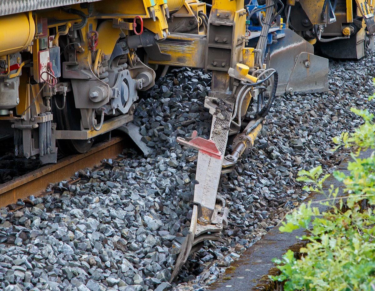
DETAIL-Bild:
Die Plasser & Theurer Schnell-Schotterplaniermaschine SSP 110 SW,  Schweres Nebenfahrzeug Nr. D-DGU 99 80 9425 069-8 (ex 97 16 46 519 18-3), am 18.08.2019 auf der Dillstrecke (KBS 445) bei Wilnsdorf-Rudersdorf im Einsatz.
Der Schotter wird mit dem Seitenpflug planiert.

