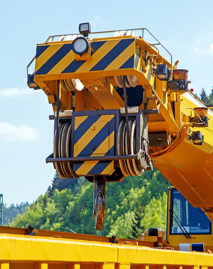 
Detailbild von vorne: 
Das obere Ende von Teleskopausleger, die Kranflasche und der Kranhaken, von dem 125t -KIROW Gleisbauschienenkran KRC 810 T der Hering Bau (Burbach), Schweres Nebenfahrzeug Nr. D-HGUI 99 80 9419 010-0, am 10.05.2015 Siegen-Eintracht.
Deutlich zusehen, das Seil ist nur zweimal umgelenkt, so wäre die halbe Last am Haken möglich, aber die Hubgeschwindigkeit die doppelte, als bei vierfacher Umlenkung.
